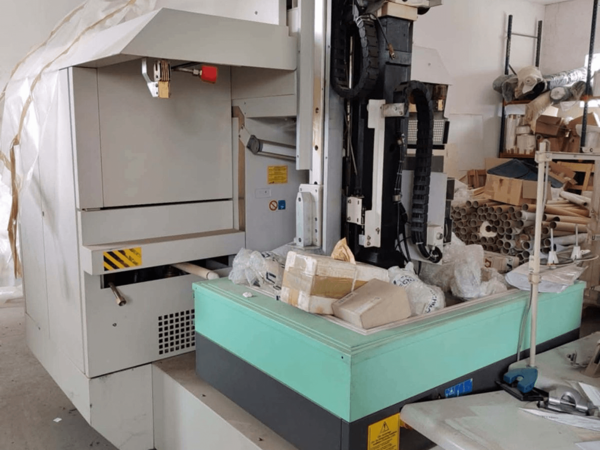 Maszyna do obróbki elektroerozyjnej matryc AGIE AGIETRON INTEGRAL 2, widok z przodu, pokazujący panel sterowania, stół roboczy i otaczający bałagan.