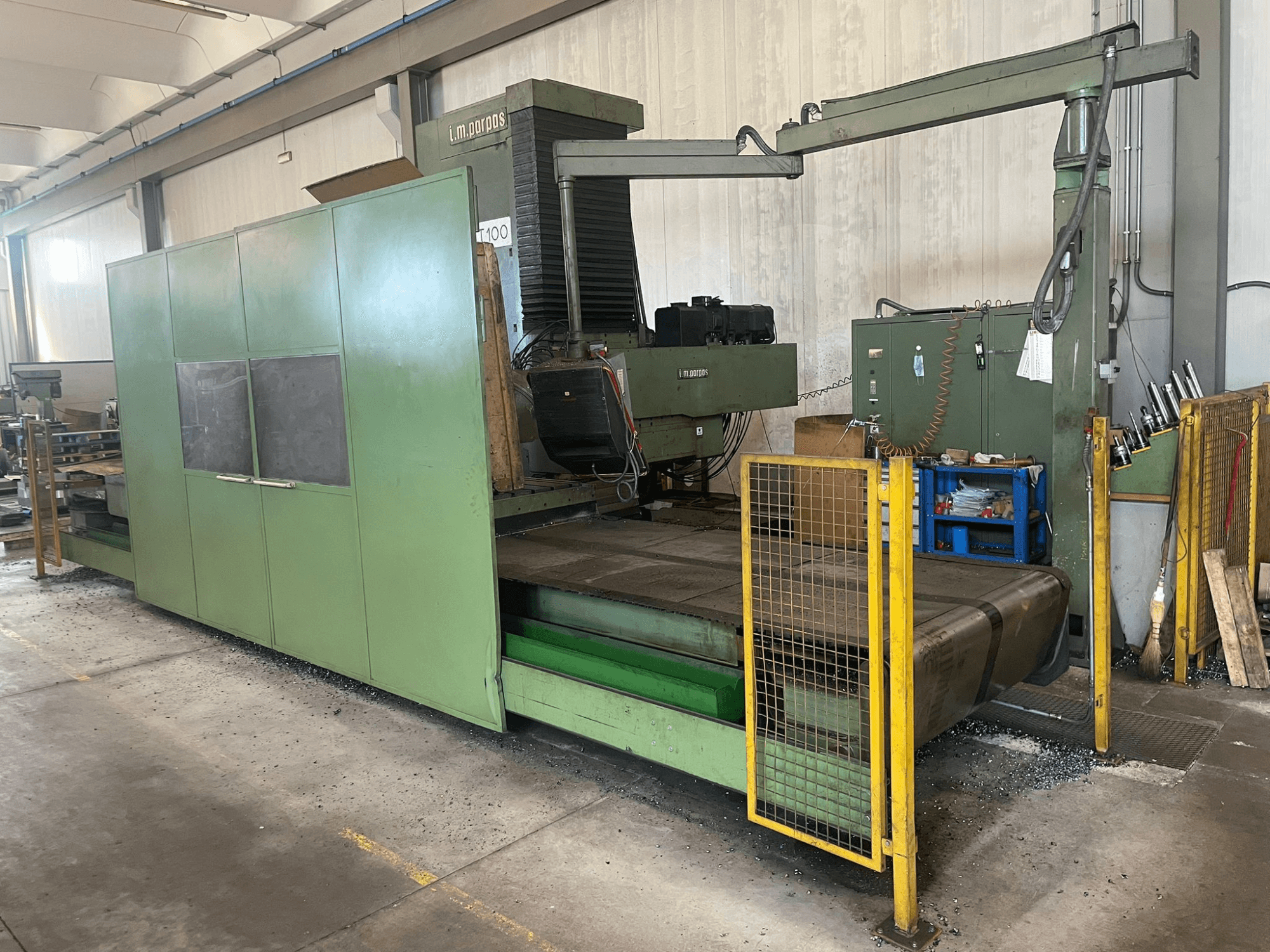 Duża zielona frezarka przemysłowa z barierkami ochronnymi, widok z przodu, z etykietą modelu "l.m. parpas" i widocznymi elementami sterującymi.