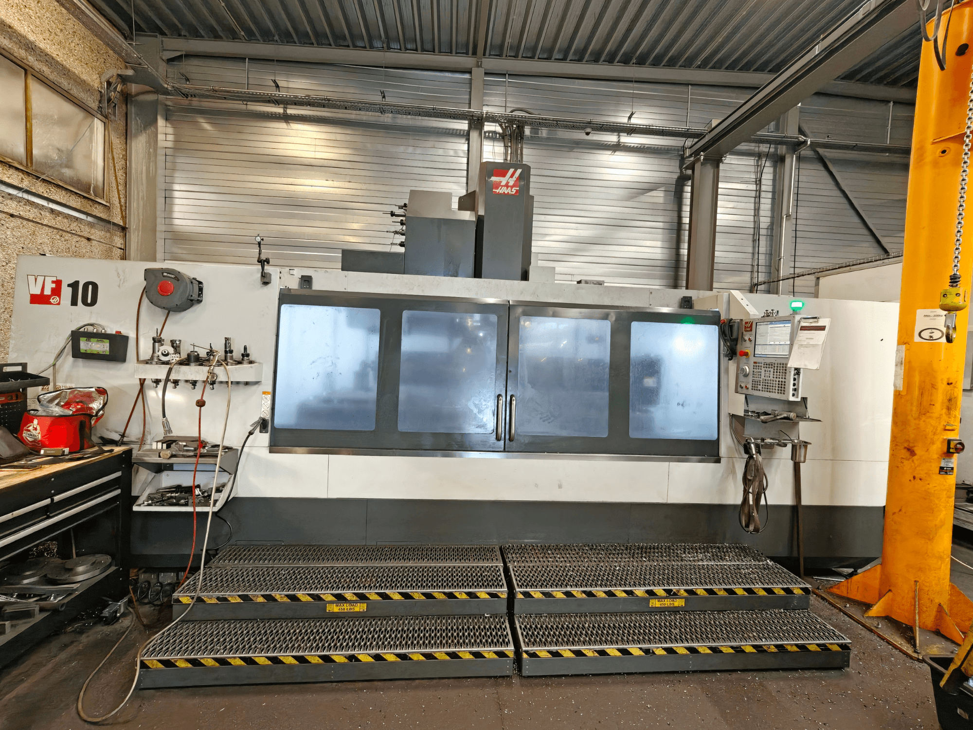 Pionowe centrum obróbcze HAAS VF-10/50, widok z przodu, z panelem sterowania oraz dużymi oknami obserwacyjnymi.