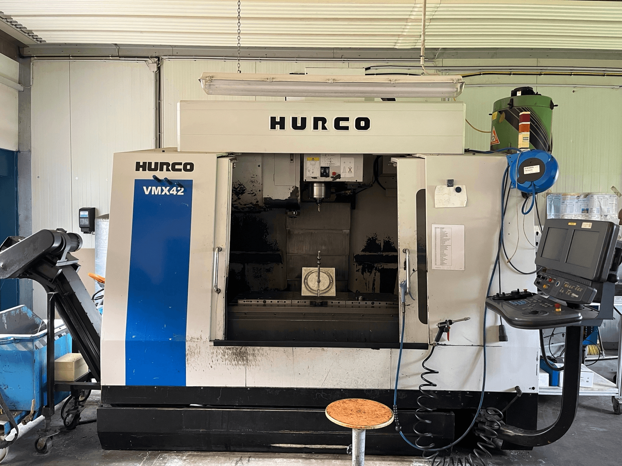 Pionowe centrum obróbcze Hurco VMX 42 w widoku z boku, pokazujące panel sterowania, wrzeciono i konfigurację przedmiotu obrabianego.