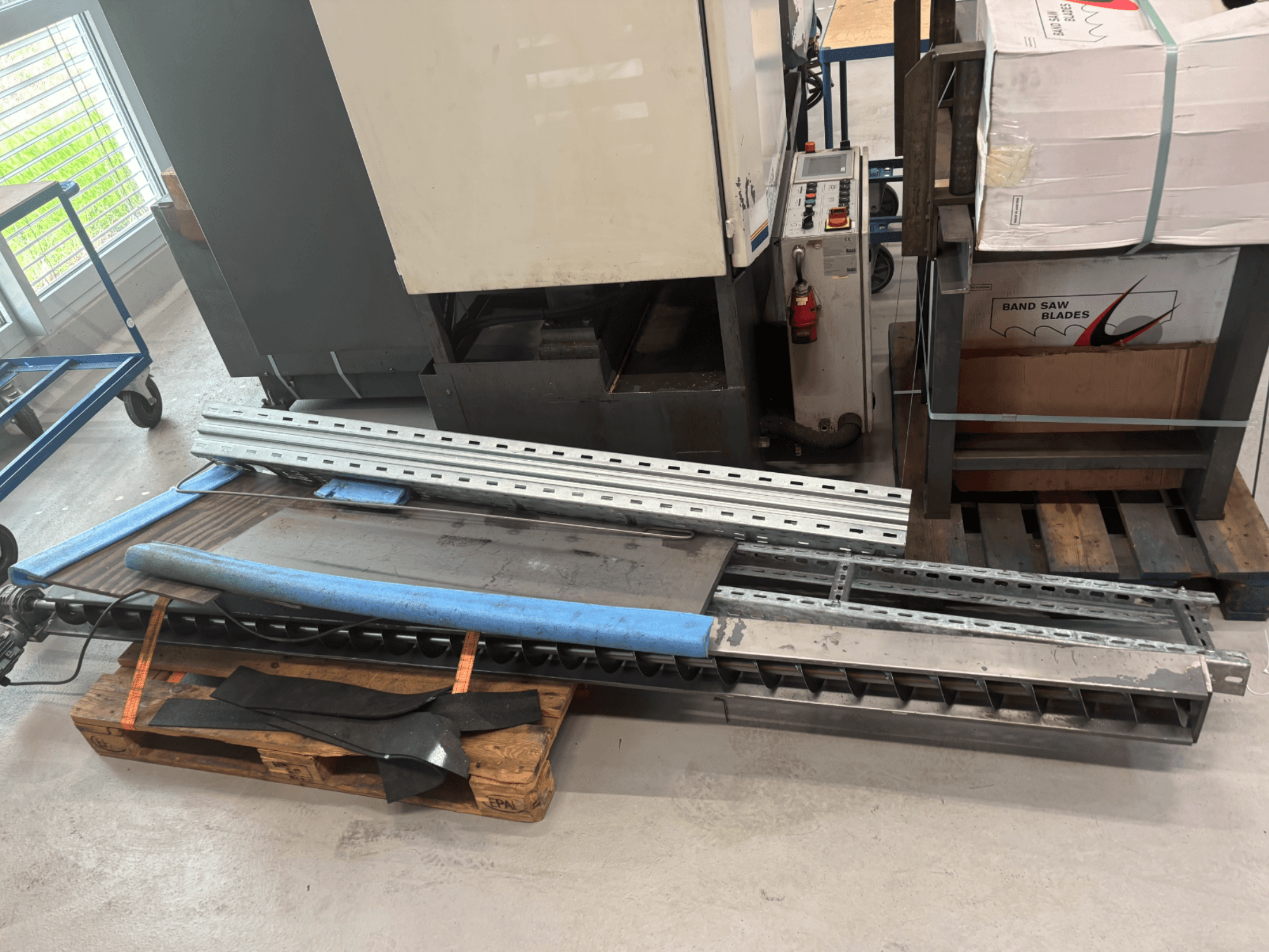 Piła taśmowa do metalu BAUER SA 430 ZA prezentowana z boku, z metalową ramą i komponentami na drewnianej palecie.