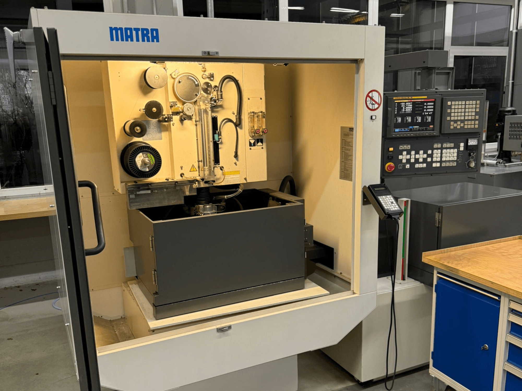 Maszyna MATRA widziana od przodu, z panelem sterowania, obracającymi się częściami i dużym schowkiem.