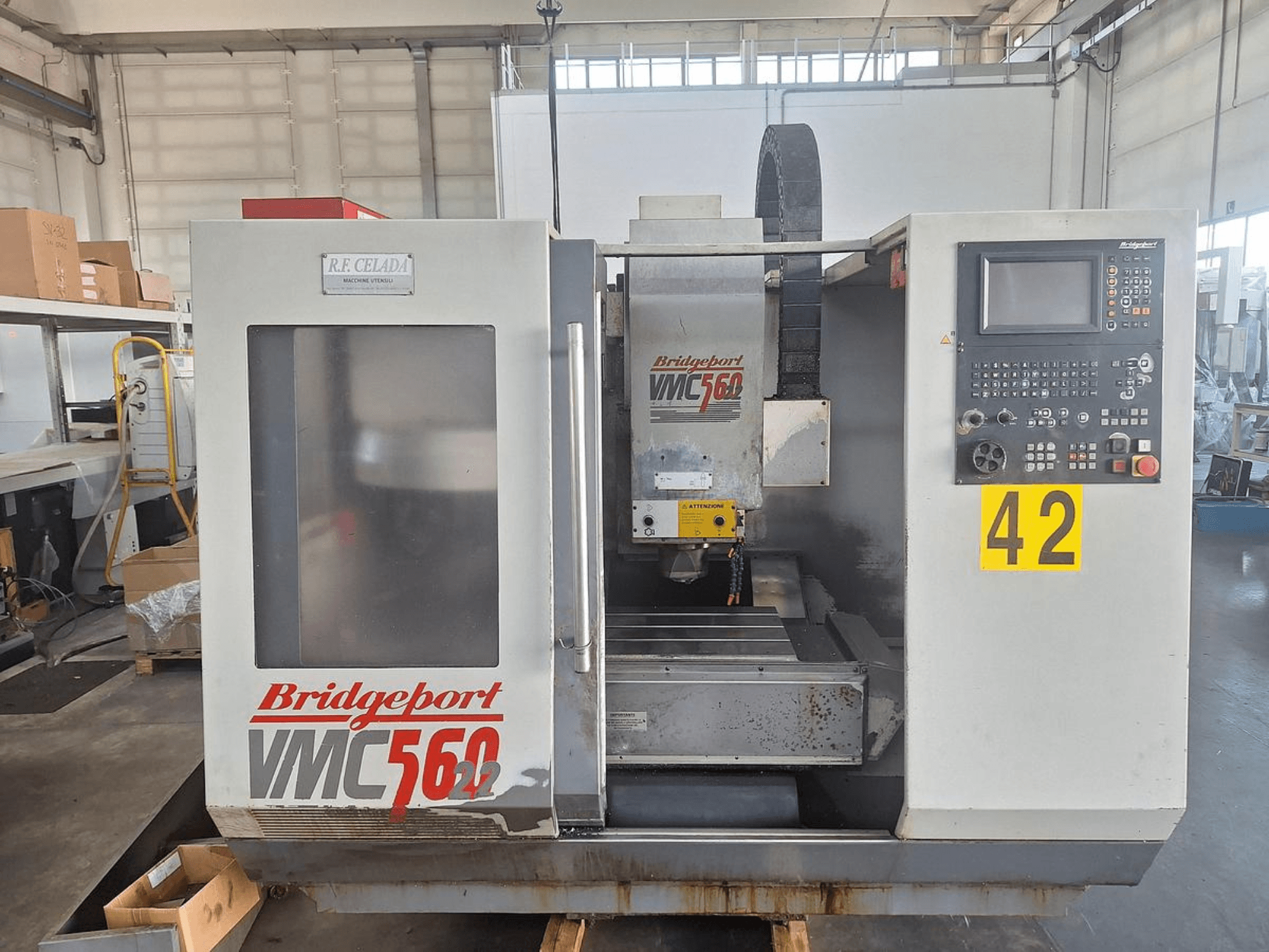 Pionowe centrum obróbcze Bridgeport VMC 560/22, widok z przodu, z panelem sterowania, uchwytem narzędziowym i obszarem roboczym.