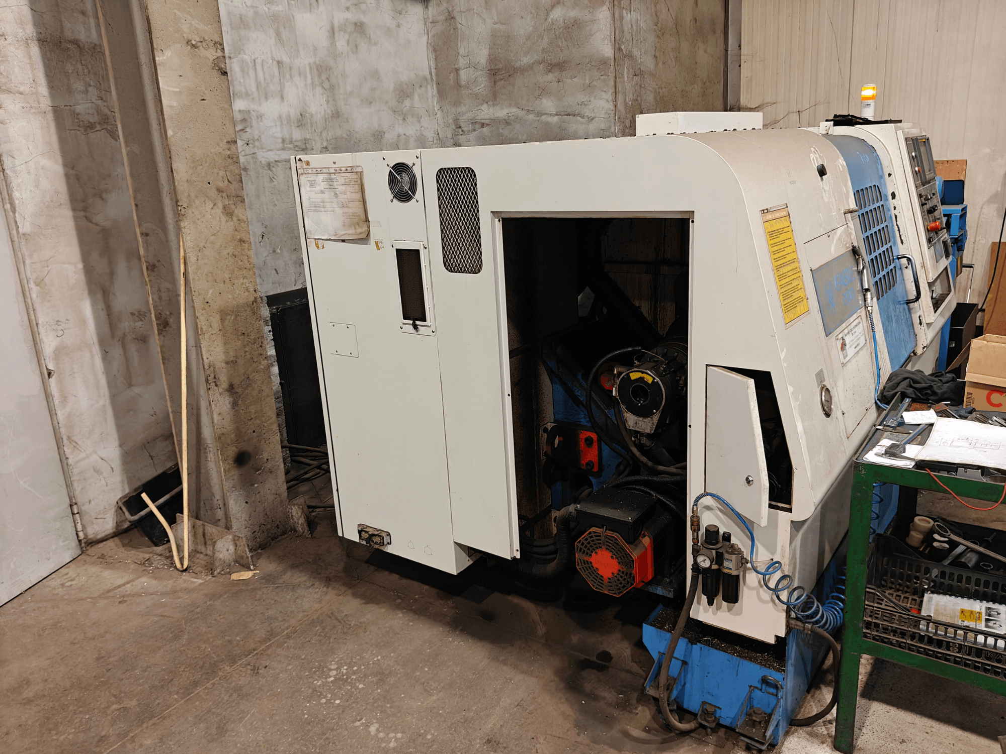 Widok z przodu tokarki, marka i model nieokreślone, z elementami sterującymi i widocznymi komponentami silnika.