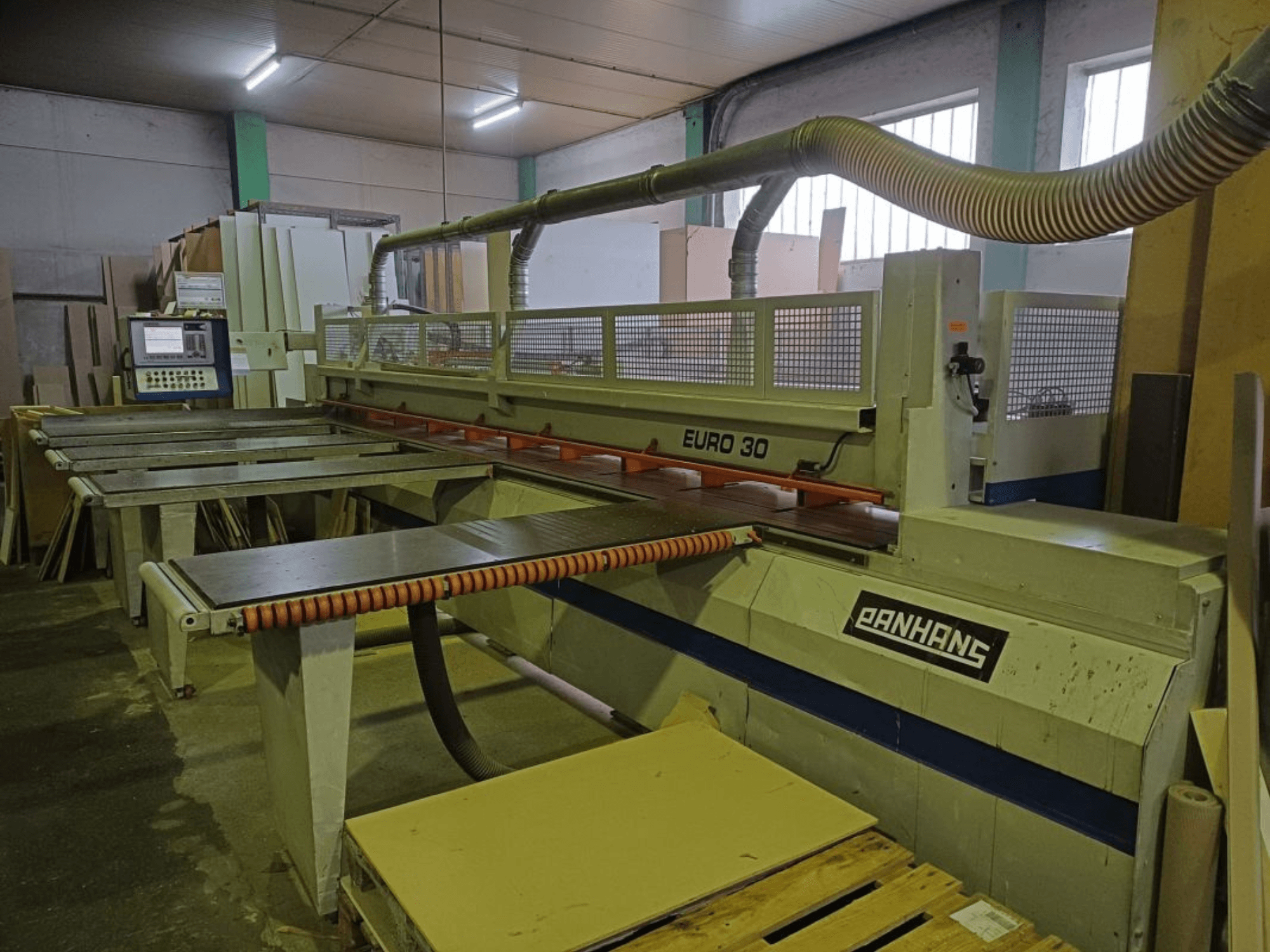 Widok z przodu pilarki panelowej PANHANS EURO 30 z panelem sterowania, stołem do cięcia i wężem do odsysania pyłu w warunkach warsztatowych.