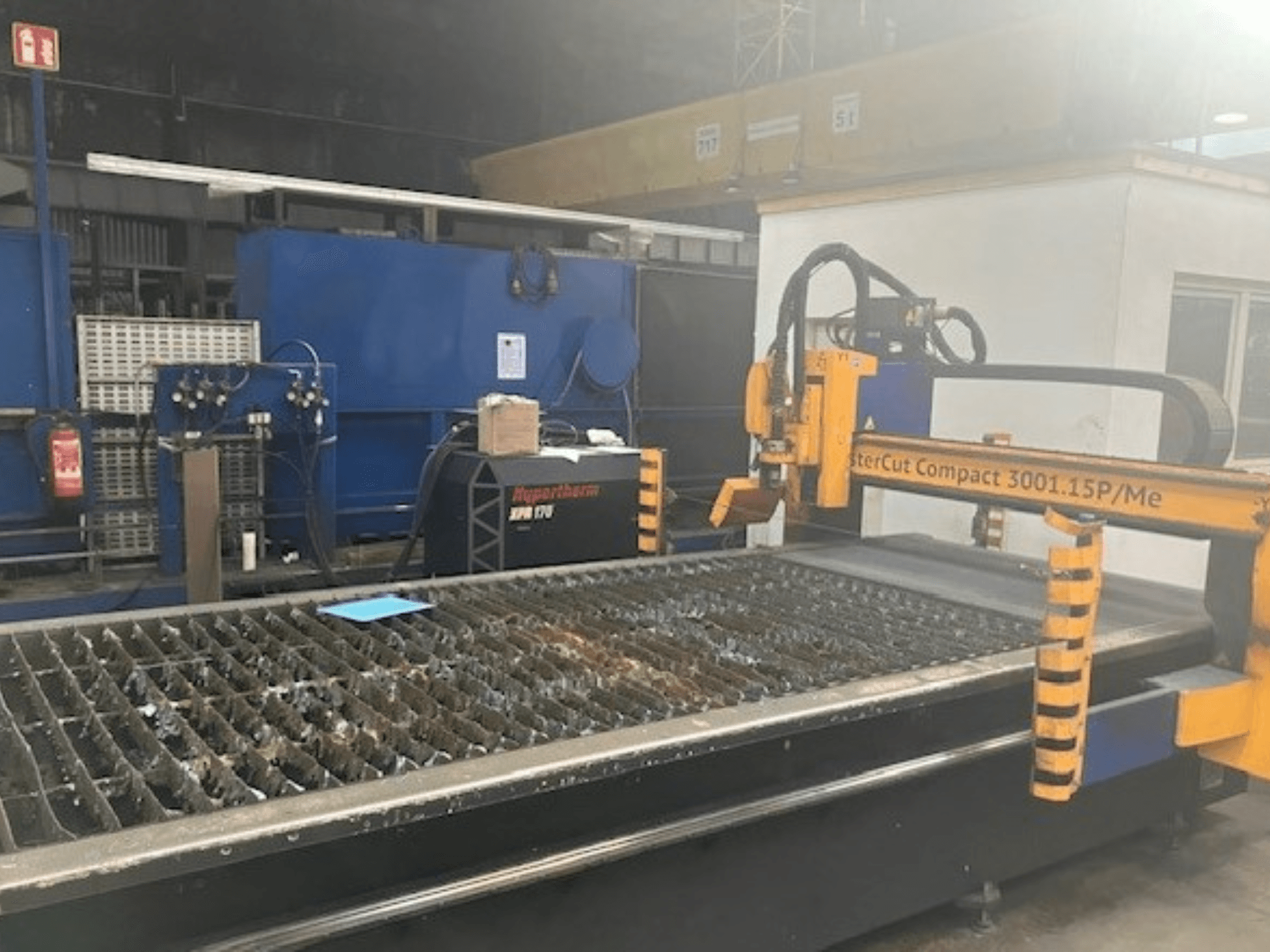 Maszyna do cięcia plazmowego Hypertherm MasterCut Compact 3001.15P/Me w widoku z boku, pokazująca stół do cięcia i panel sterowania.