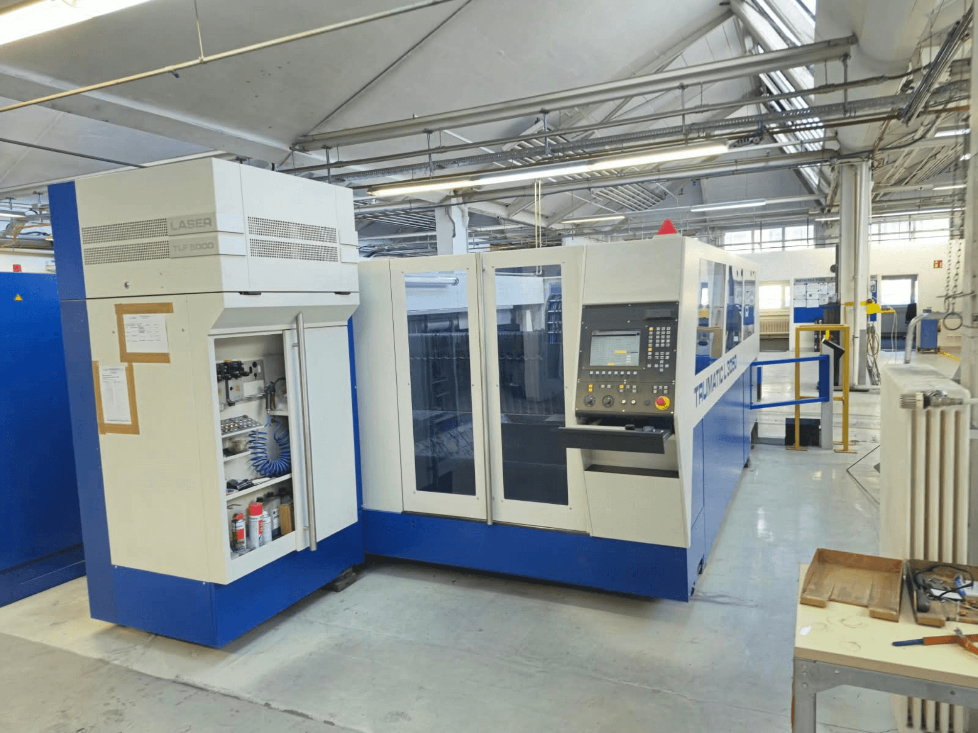 Maszyna do cięcia laserowego CO₂ TRUMPF TruLaser L3050, widok z przodu, z panelem sterowania i drzwiczkami serwisowymi, w stanie fabrycznym.