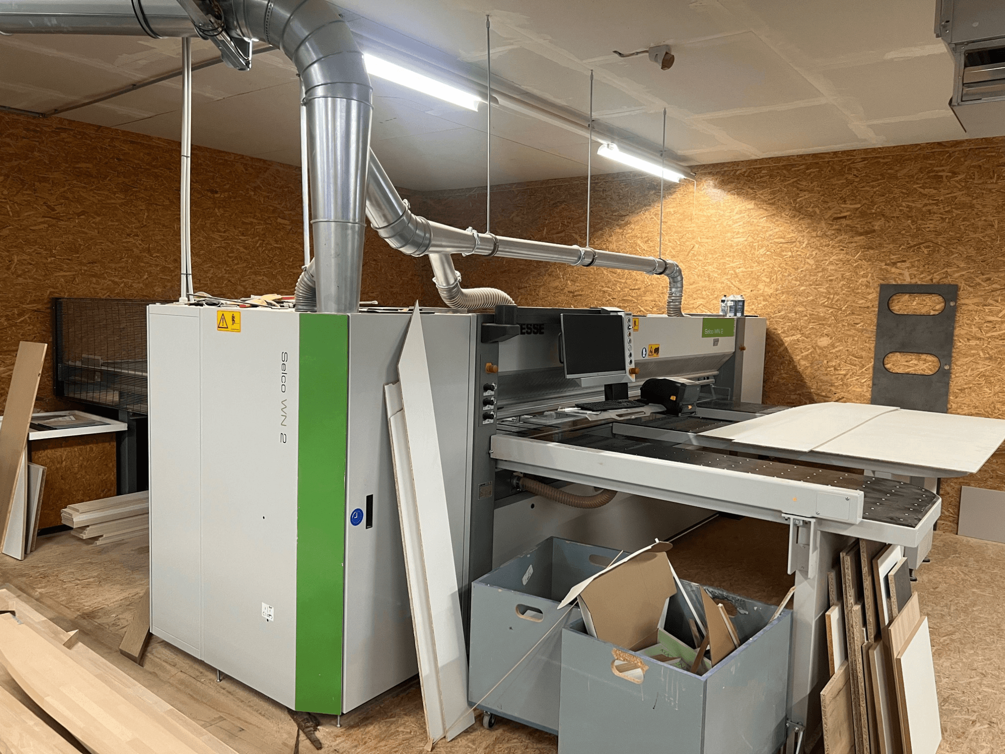 Piła panelowa BIESSE Selco WN 2 w warsztacie, wyposażona w duży stół do cięcia i system odsysania pyłu, widok z boku.