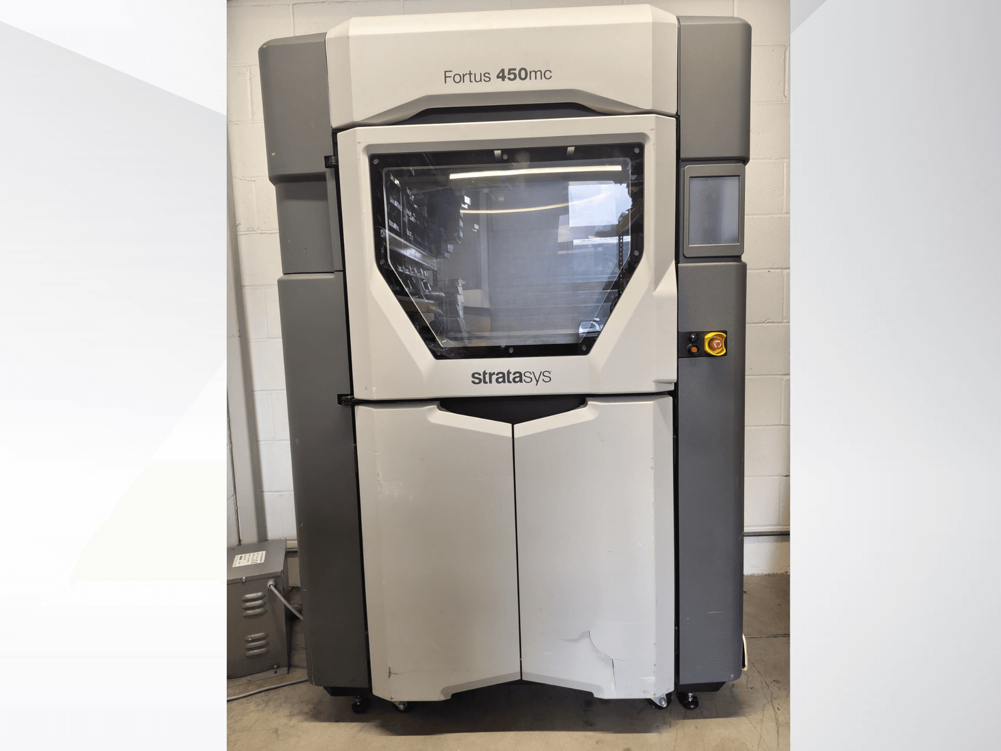 Maszyna do obróbki tworzyw sztucznych Stratasys Fortus 450mc – widok z przodu, z dużym okienkiem, panelem sterowania i przemysłową stylistyką.