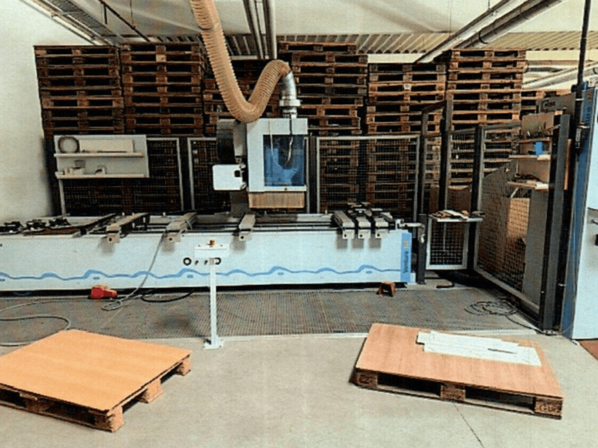 Centrum obróbcze CNC do drewna Weeke Venture 1M w warsztacie, widok z przodu z widocznymi drewnianymi paletami i konfiguracją przemysłową.