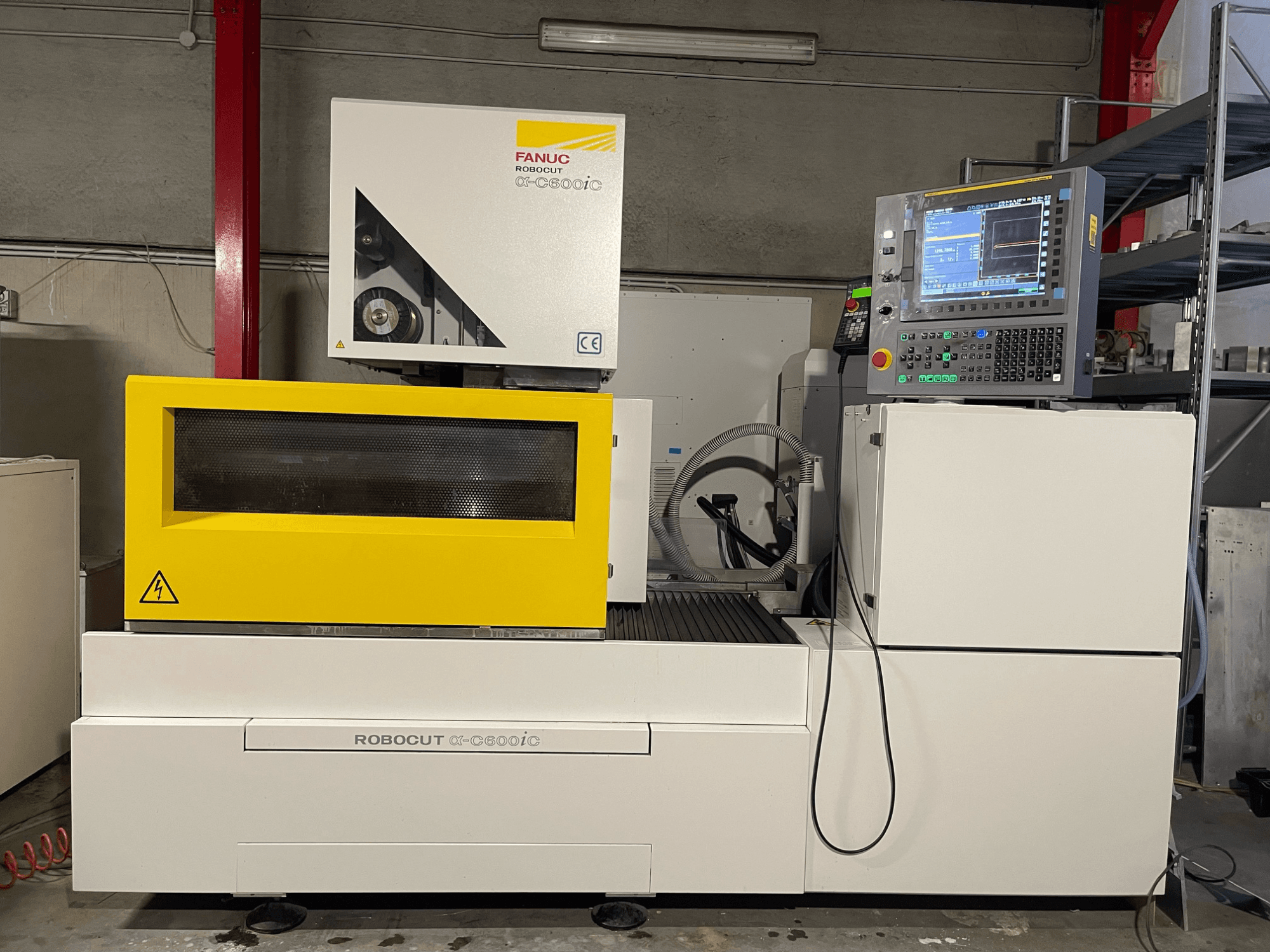 FANUC Robocut α-C600iC, widok z boku maszyny CNC z żółtą osłoną bezpieczeństwa i panelem sterowania, prezentujący możliwości precyzyjnego cięcia.