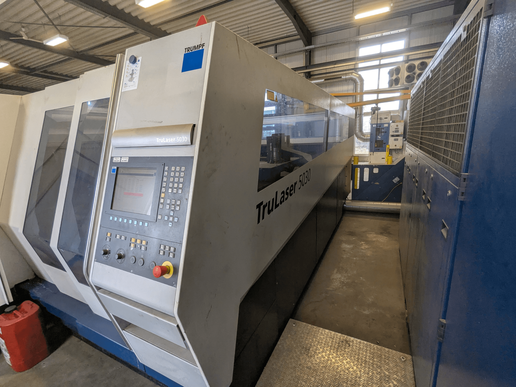 Wycinarka laserowa CO2 TRUMPF TruLaser 5030, widok z przodu przedstawiający panel sterowania i elegancką konstrukcję, w warunkach przemysłowych.
