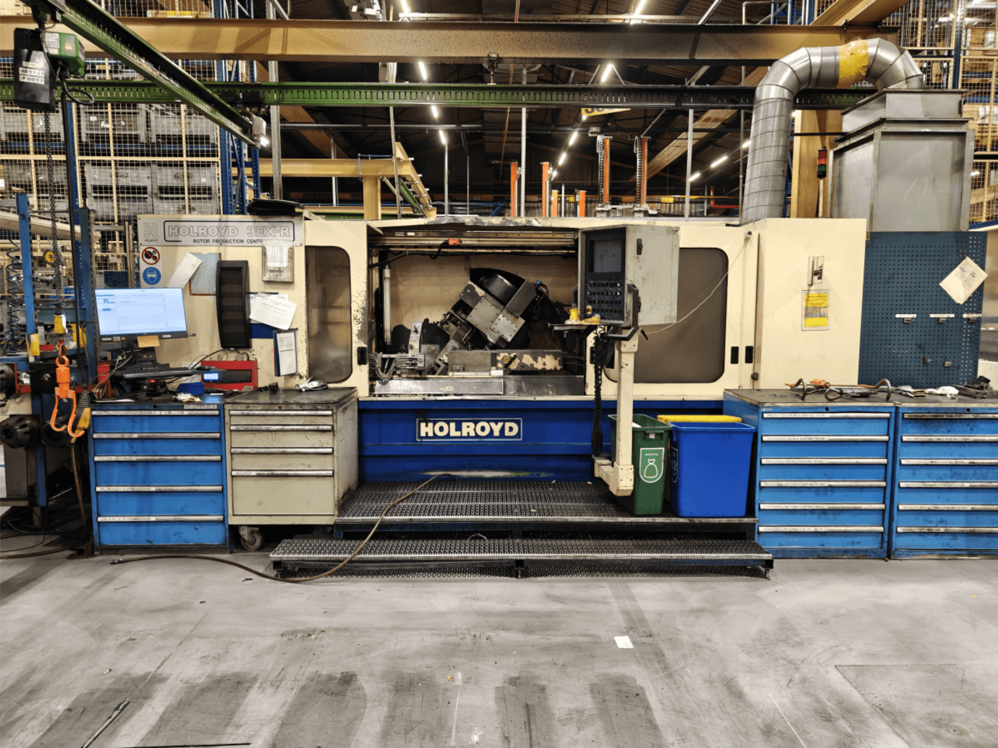 Obrabiarka Holroyd 3EX-R w warsztacie, widok z przodu, pokazujący panel sterowania, magazyn narzędzi i obszar roboczy wewnątrz.