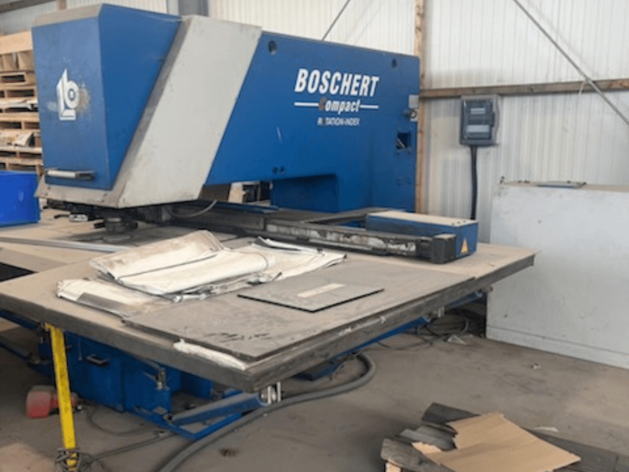 Wykrawarka CNC BOSCHERT COMPACT 1000 w warsztacie – widok z przodu z blachami na stole.