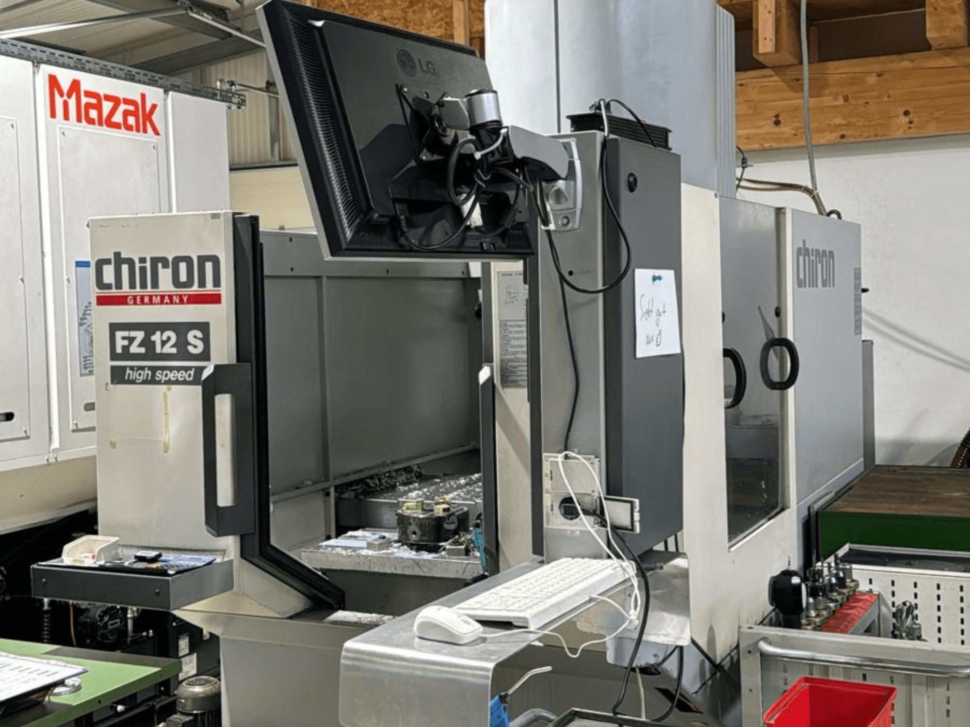 Widok pionowy szybkiego centrum obróbczego CHIRON FZ 12 S z ekranem sterowania i odpadami z procesu obróbki.