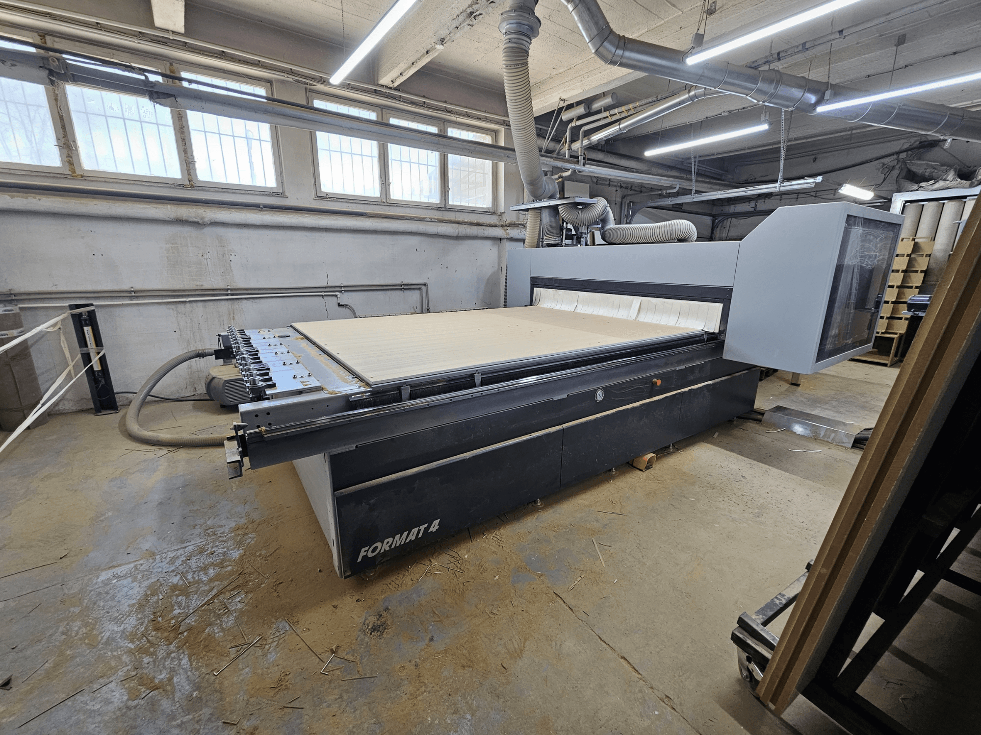 Ploter CNC FORMAT4 Profit H80 21.31, widok z boku przedstawiający duży stół roboczy i panel sterowania w warunkach warsztatowych.