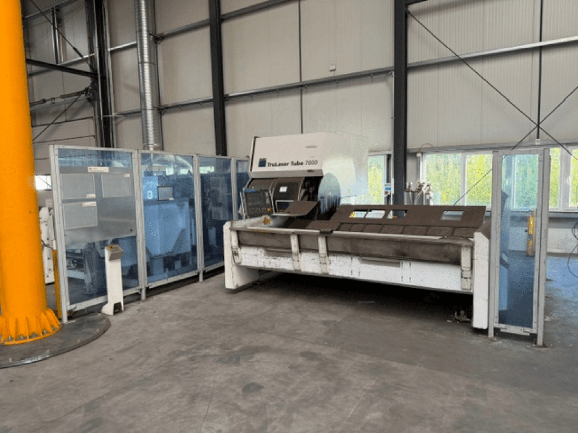 TruLaser Tube 7000 firmy TRUMPF – widok z przodu maszyny do cięcia rur w dobrze oświetlonym otoczeniu przemysłowym, z widocznymi elementami sterującymi.