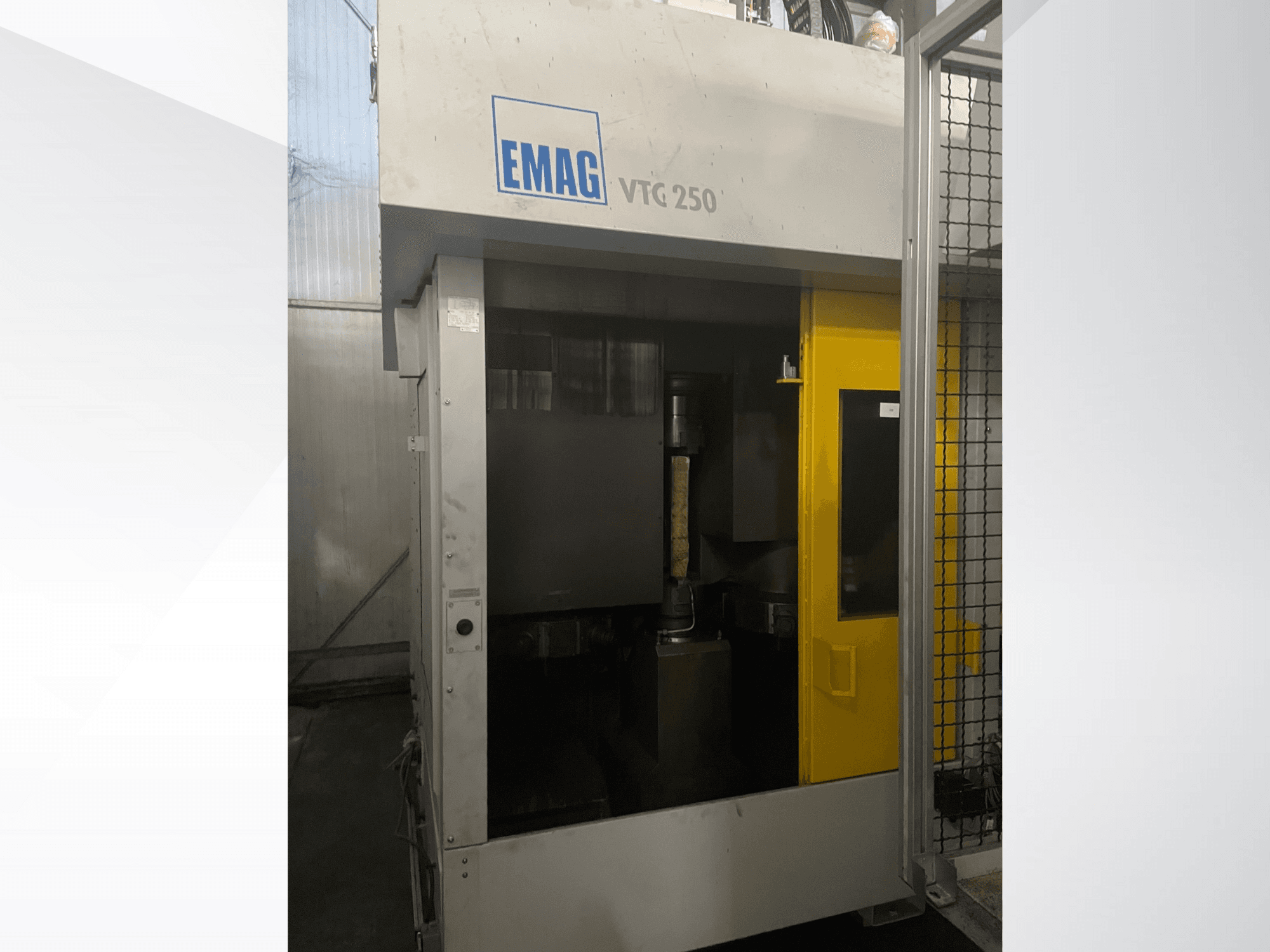 Pionowe centrum obróbcze EMAG VTC 250 w widoku z przodu, z żółtymi drzwiami i widocznym narzędziem tnącym wewnątrz komory.