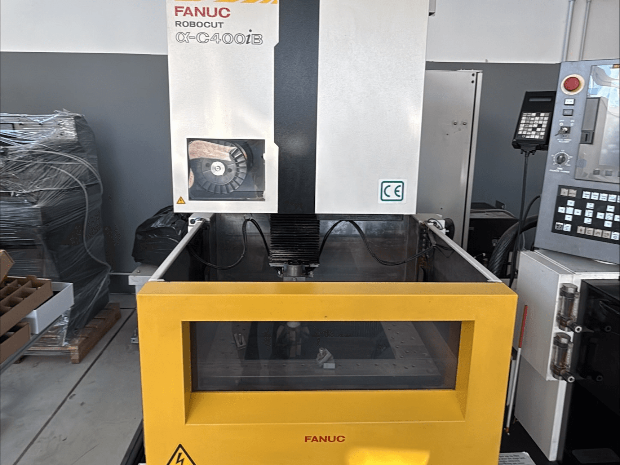 Elektrodrążarka drutowa FANUC Robocut α-C400iB, widok z przodu, z żółtym zbiornikiem i panelem sterowania.
