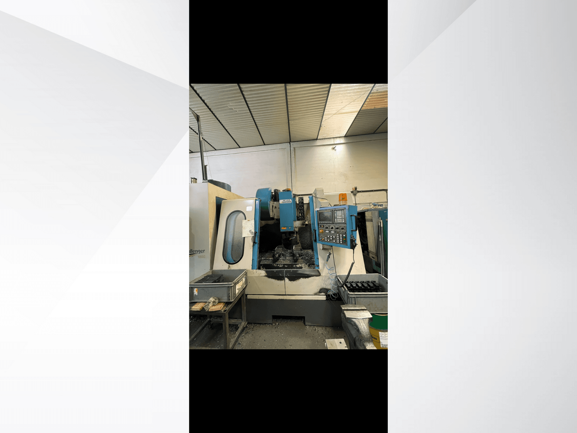Maszyna CNC, model Challenger 1500, widok z boku pokazujący panel sterowania i obszar roboczy z metalowymi wiórami.