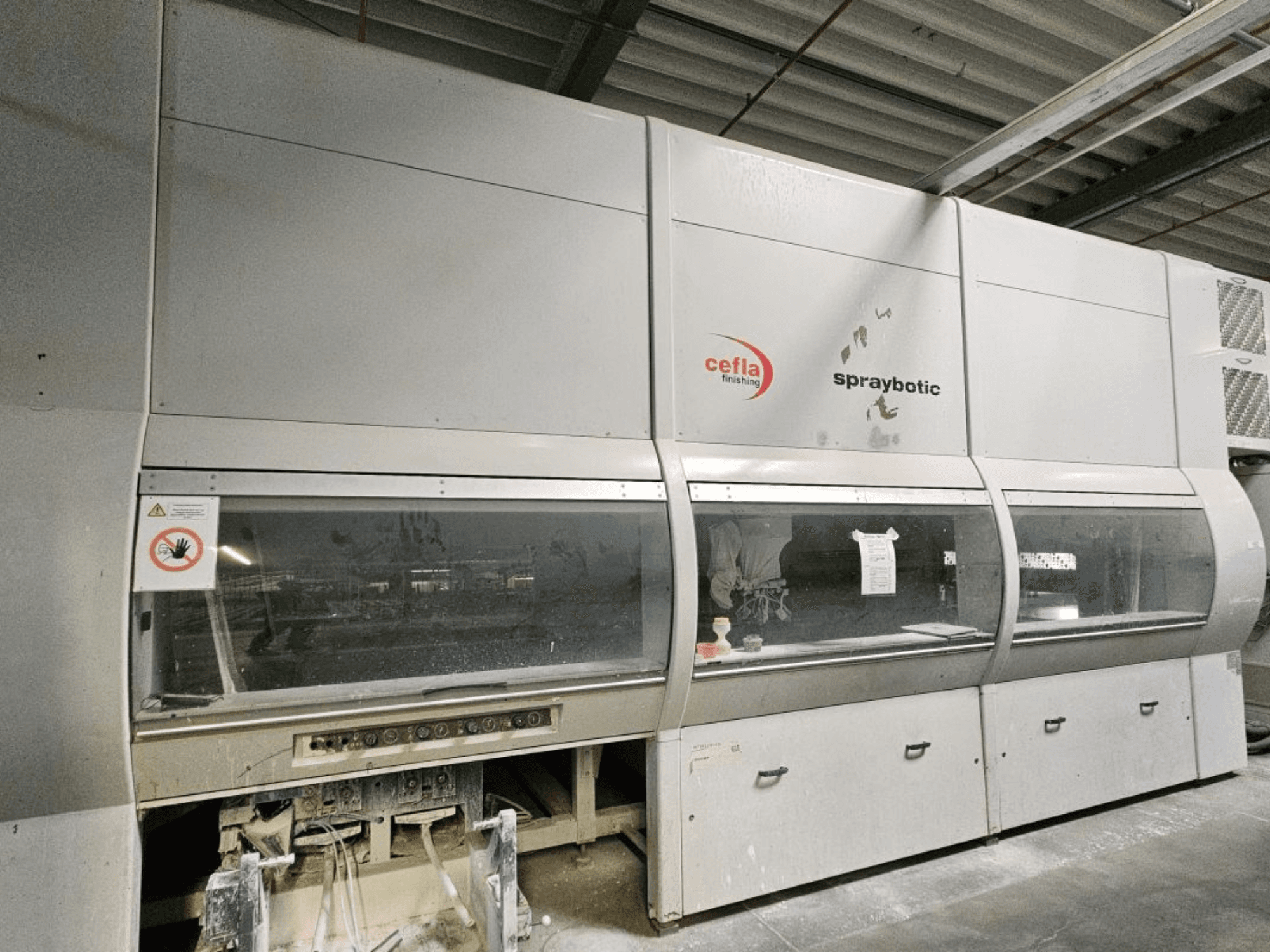 Linia produkcyjna Cefla Spraybotic MD do drewna, widok z przodu, panel sterowania i przezroczyste okna wyświetlacza.