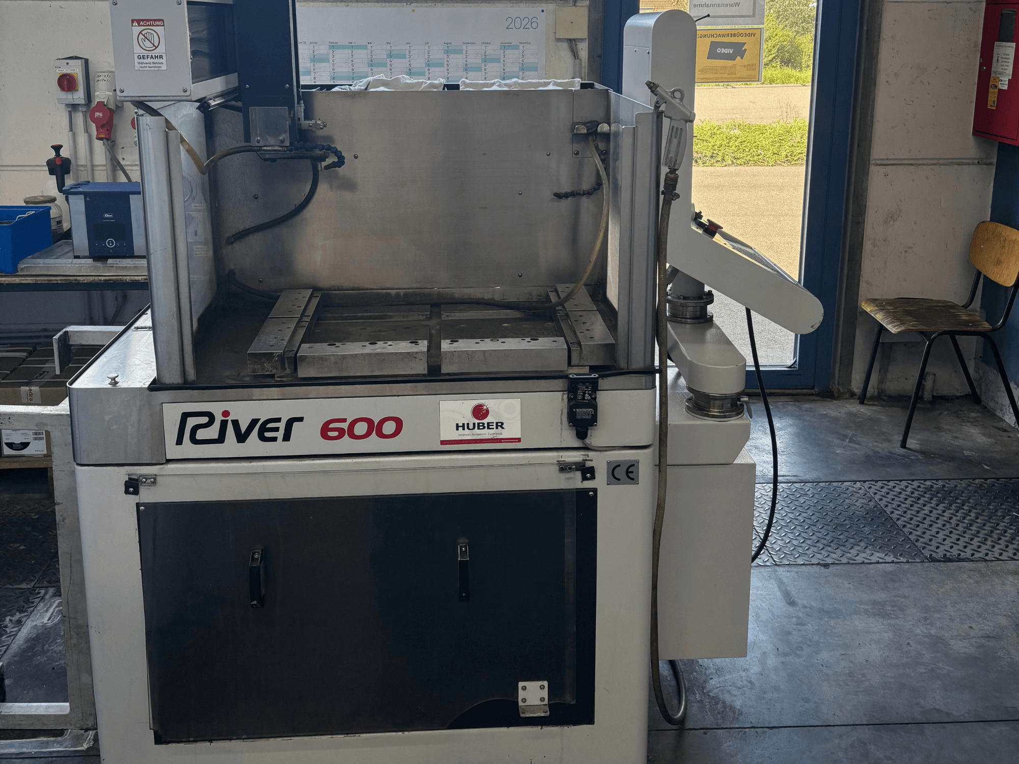 Maszyna do elektroerozji wgłębnej HUBER River 600 CNC, widok z przodu, z częściowo otwartą komorą roboczą i panelem sterowania.