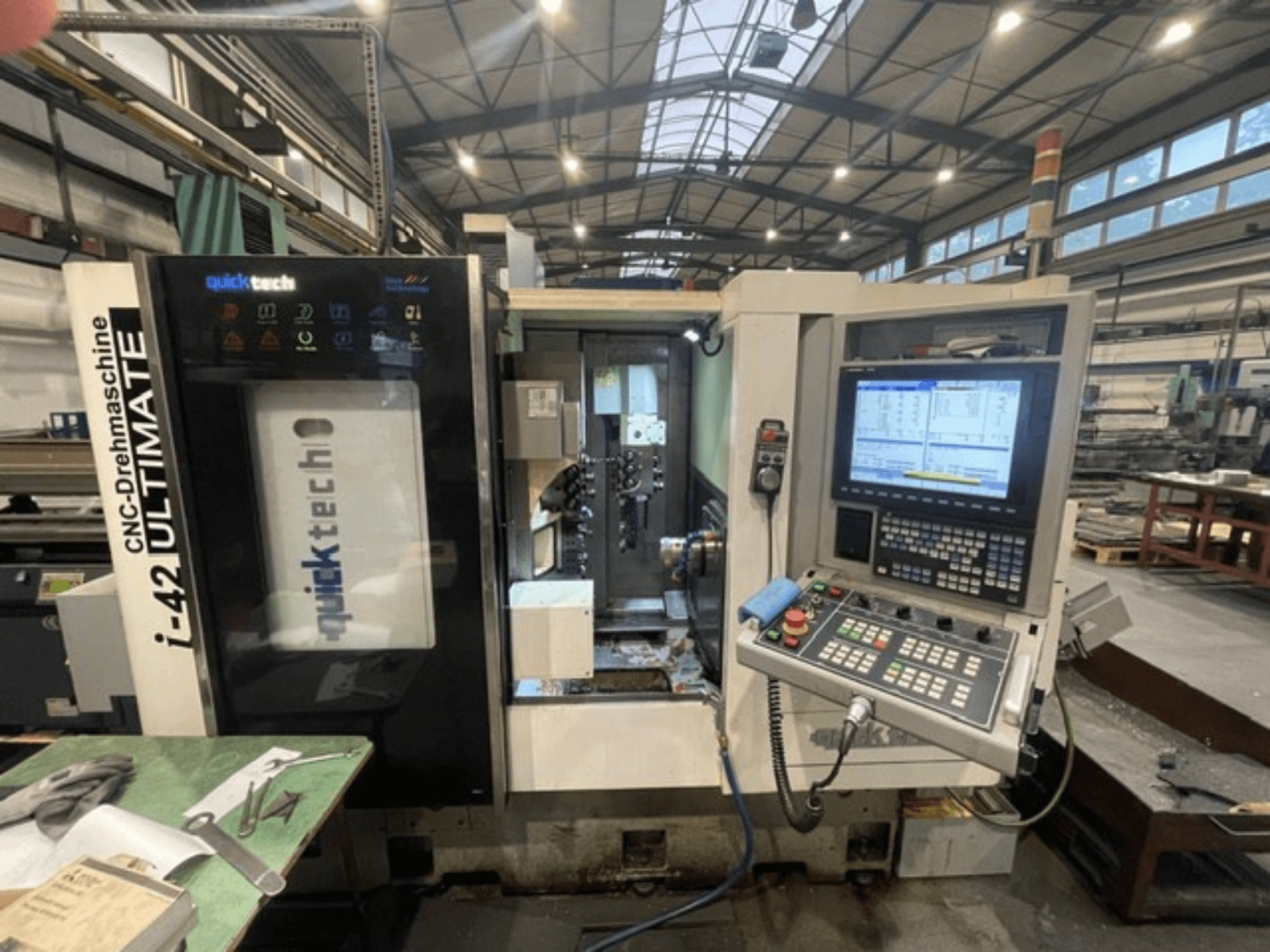 Tokarka szwajcarska Quick-Tech I-42U, widok z przodu, panel sterowania i interfejs CNC w warunkach warsztatowych.