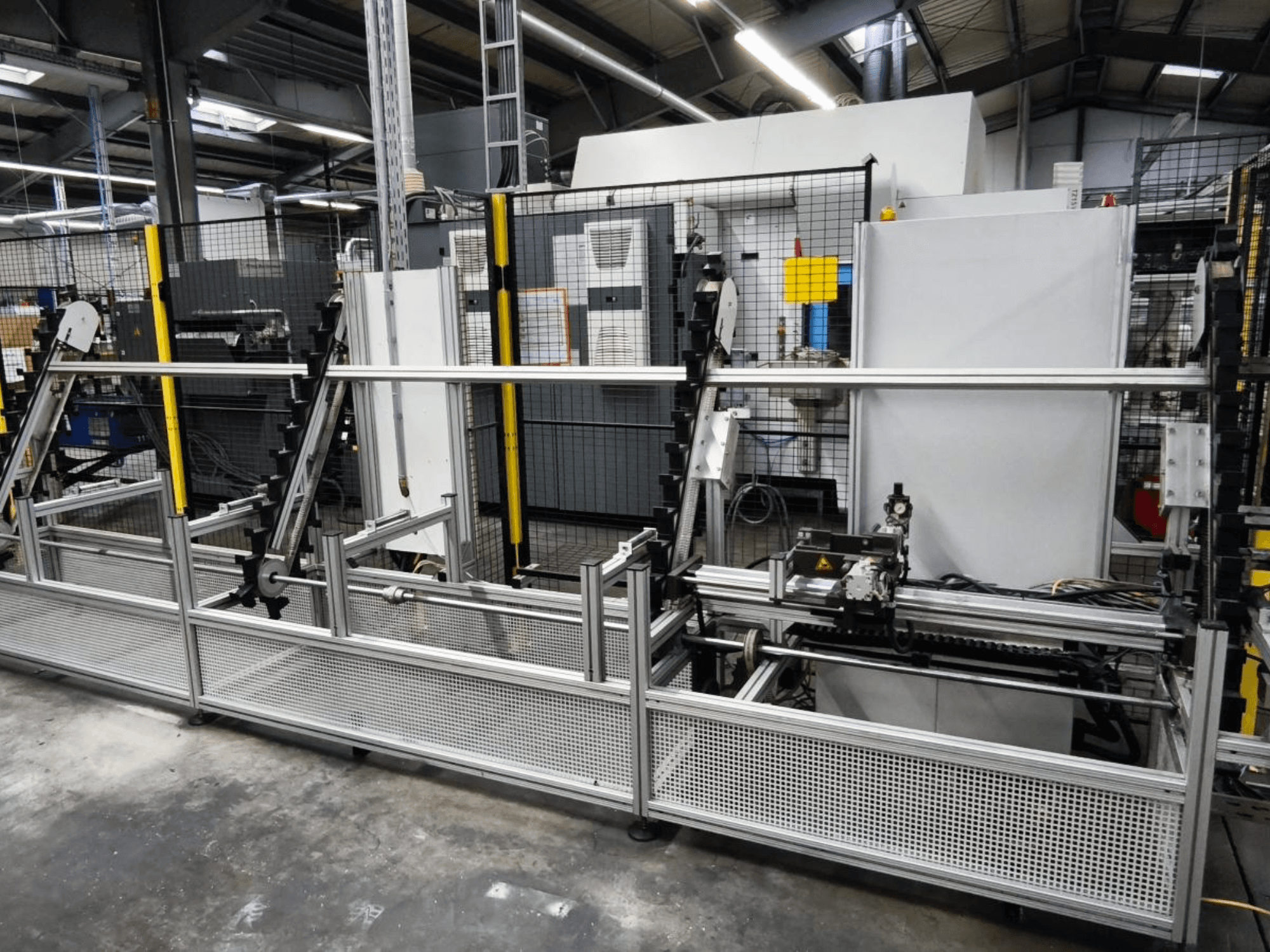 System przenoszenia detali LOHMEIER Schräglademagazin w widoku z przodu, prezentujący metalową konstrukcję i zintegrowane komponenty mechaniczne.