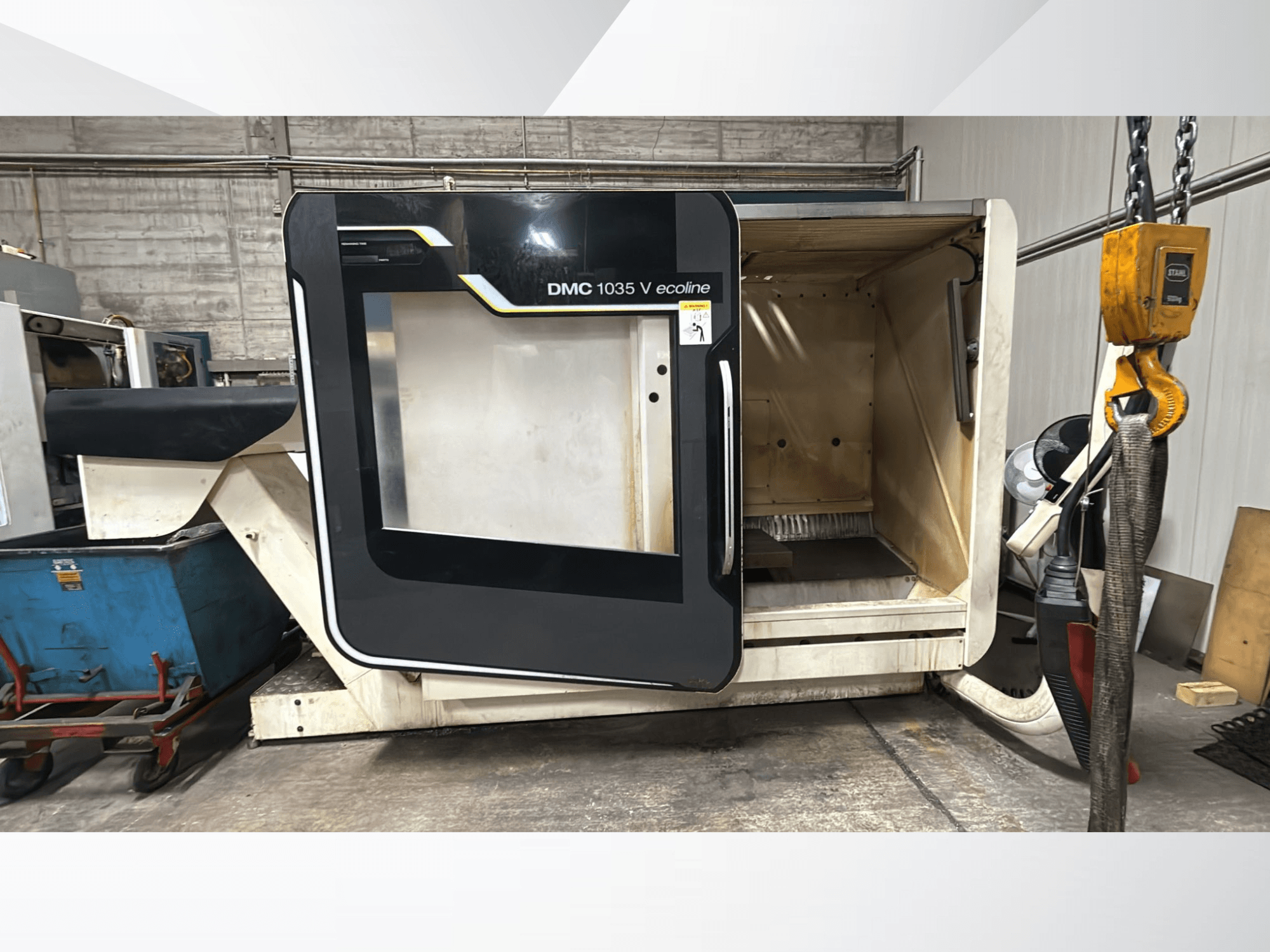 Maszyna CNC DMC 1035 V ecoline, widok z przodu, z otwartymi drzwiami odsłaniającymi puste wnętrze i panel sterowania.