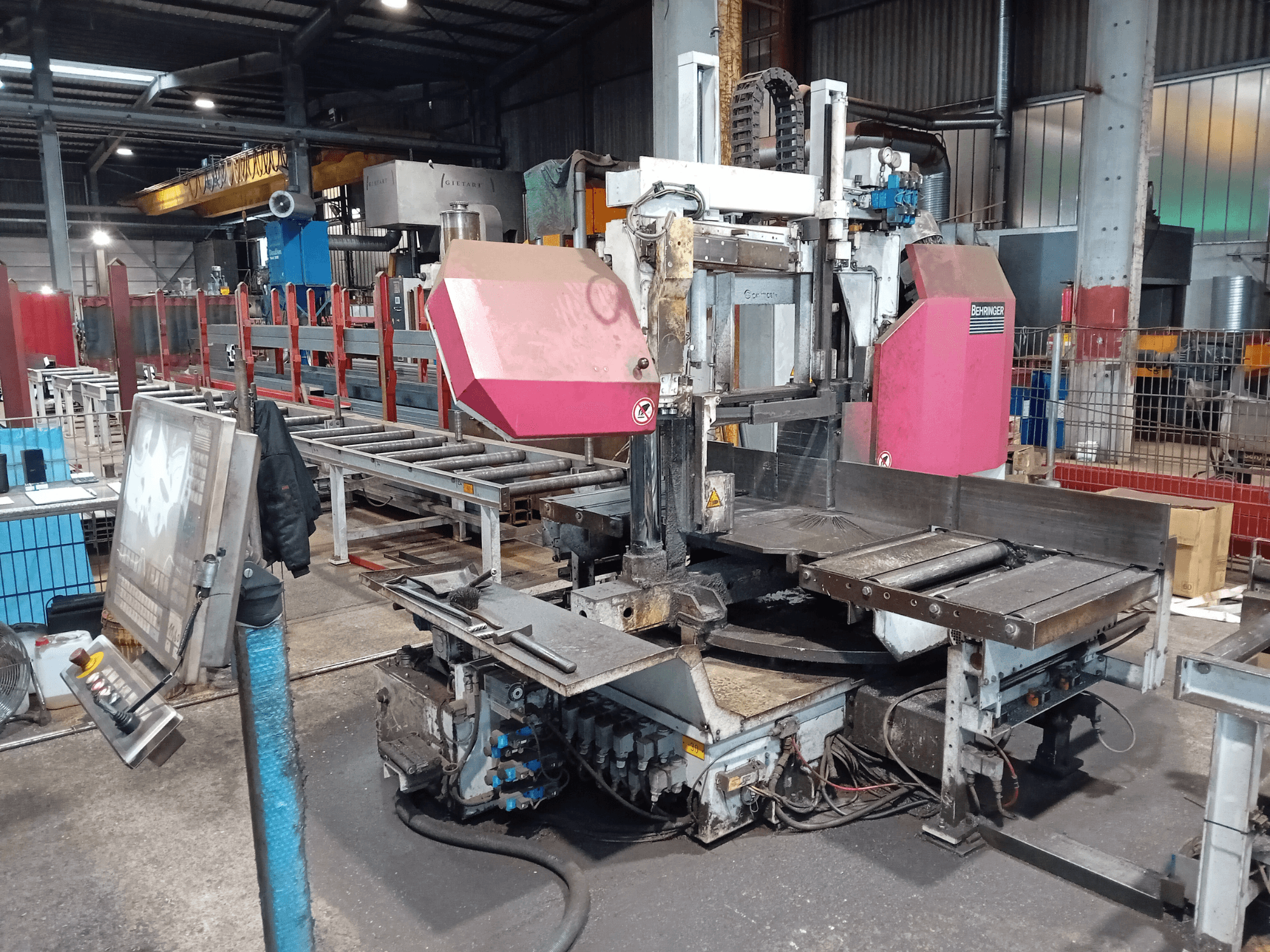 Przecinarka taśmowa Behringer w fabryce, widok z przodu, z dużą tarczą tnącą i panelem sterowania z przyciskami.