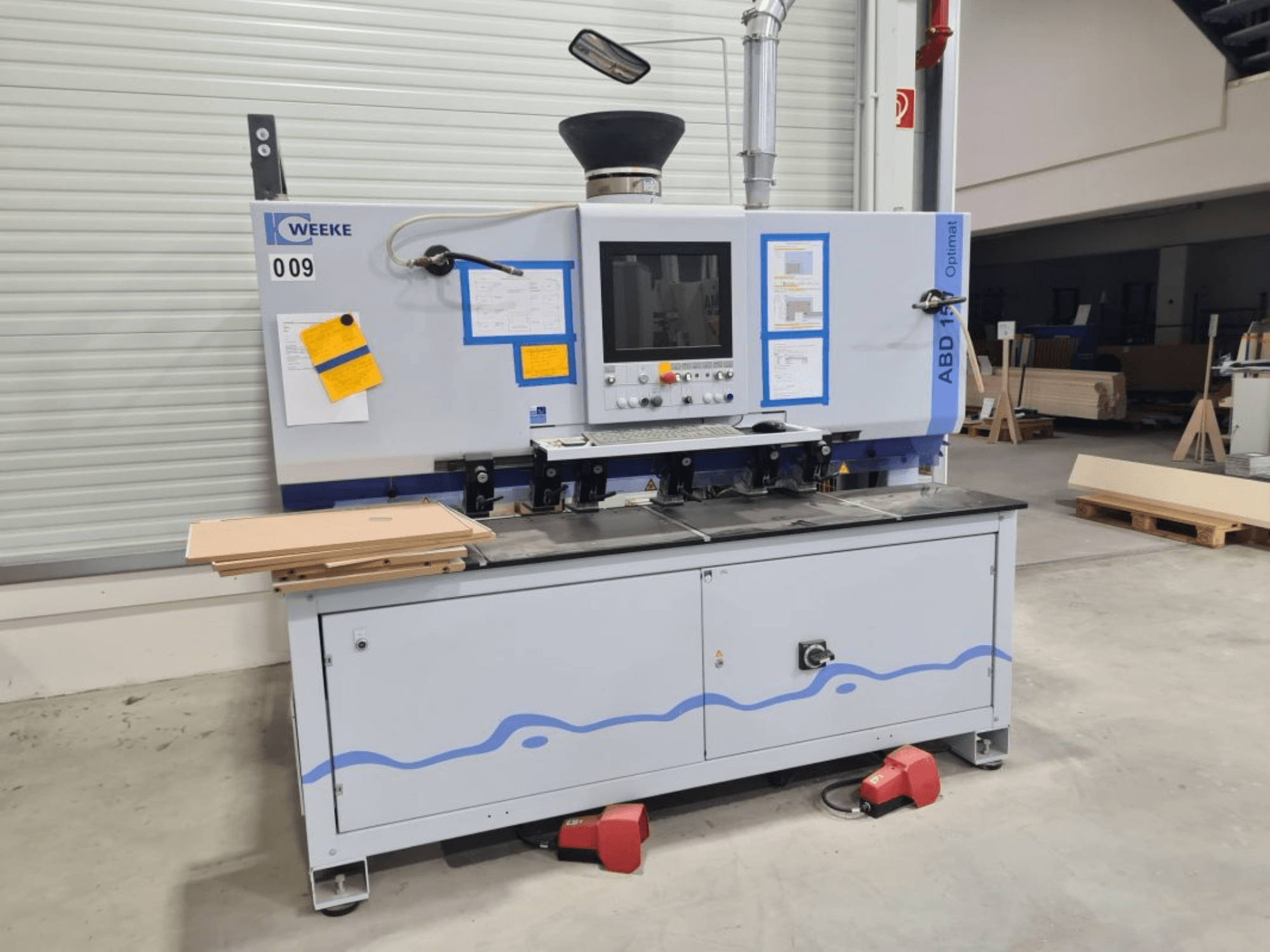 Wiertarka wielowrzecionowa HOMAG WEEKE OPTIMAT ABD150, widok z przodu, pokazujący elementy sterujące i ułożone panele drewniane.