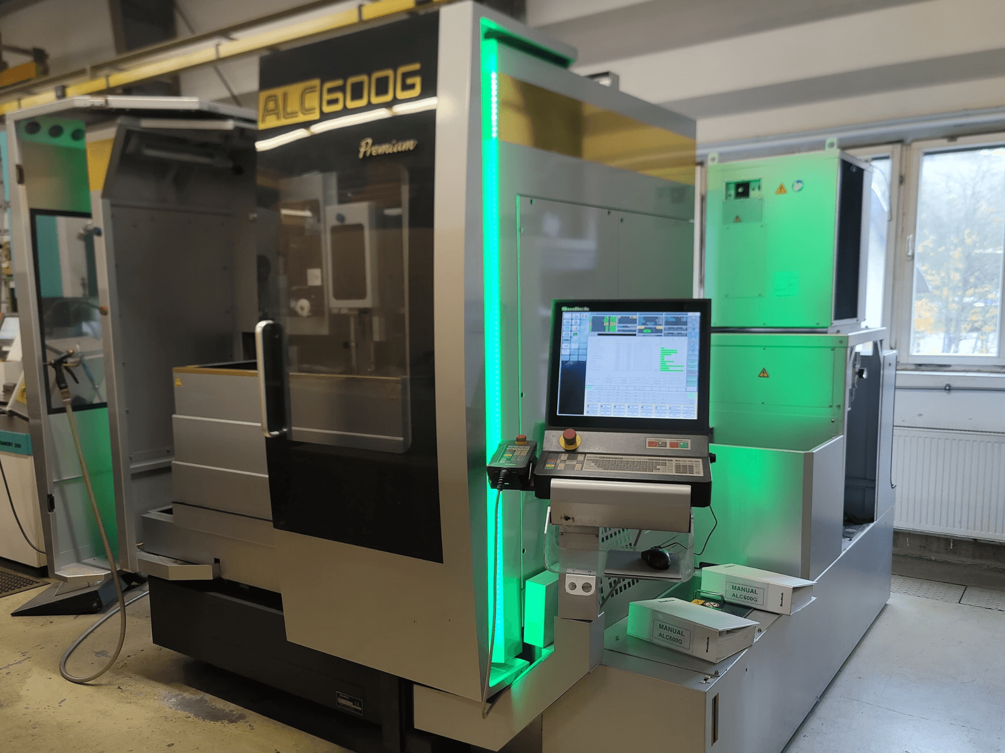 Elektrodrążarka drutowa Sodick ALC600G Premium, widok z przodu, panel sterowania i podświetlane detale zewnętrzne.