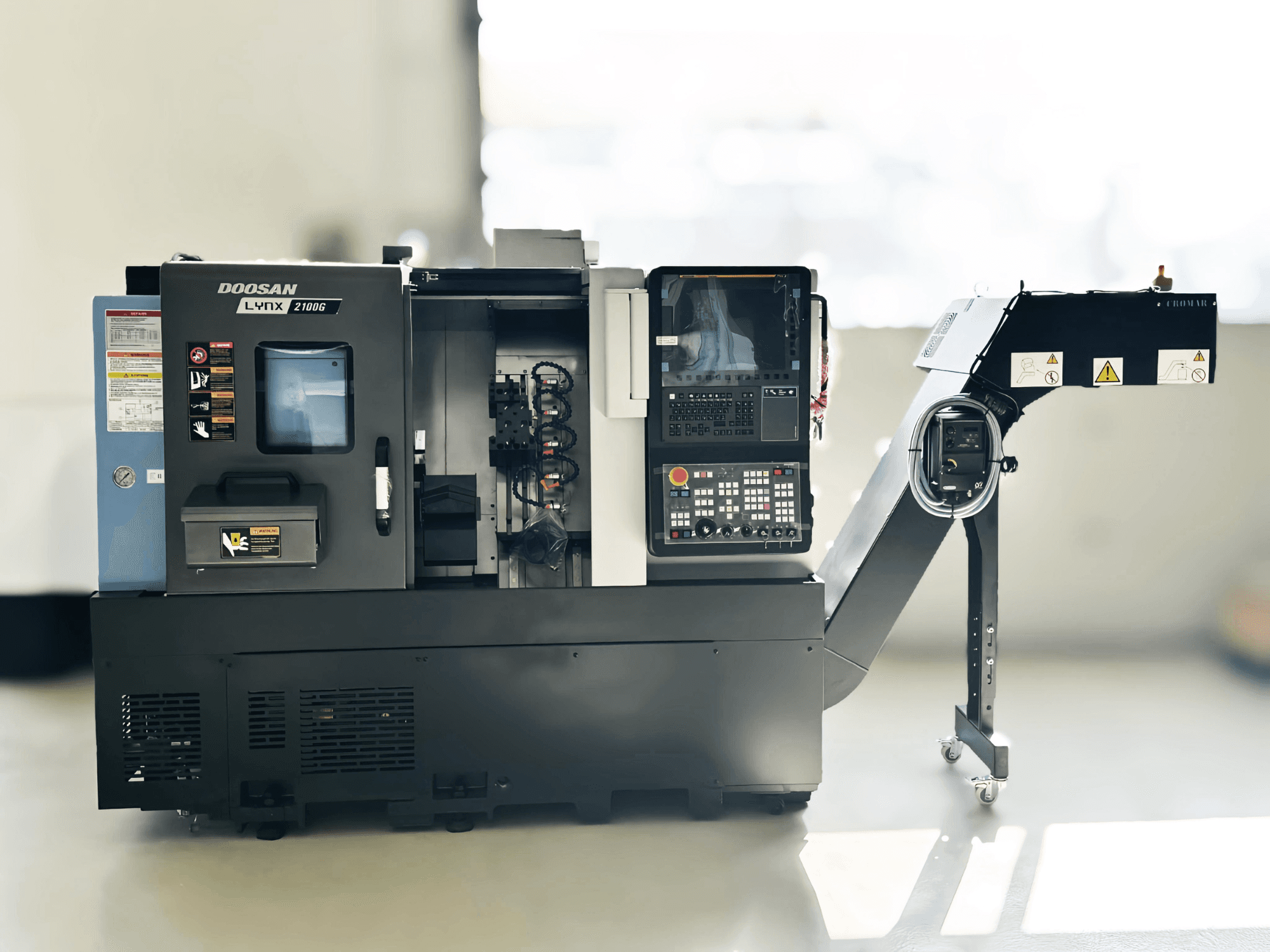 Tokarka szwajcarska DOOSAN LYNX 2100GA w widoku z boku z widocznym panelem sterowania i uchwytem narzędziowym.