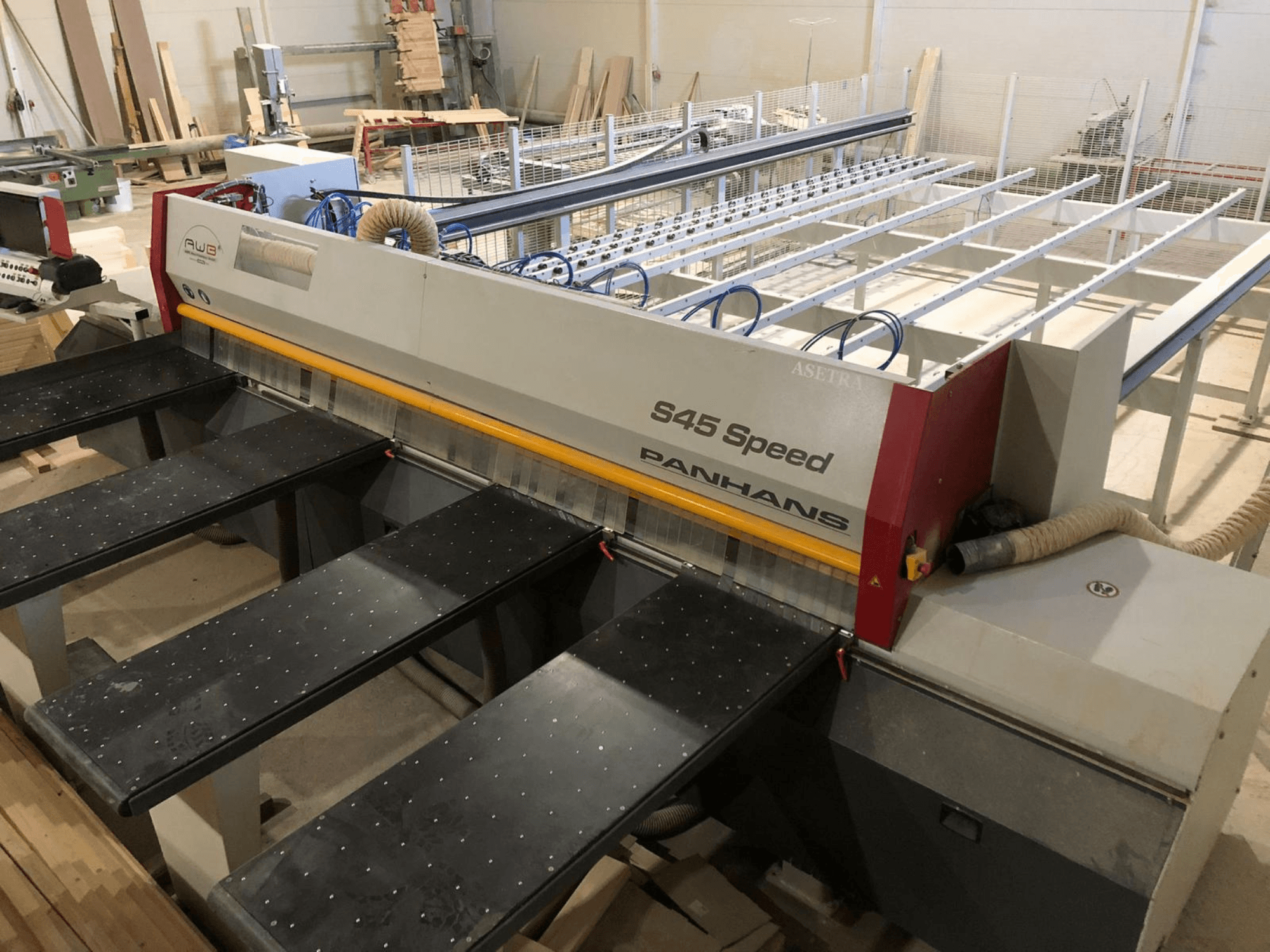 Widok z boku pilarki panelowej PANHANS S45 Speed z pięcioma stołami i widocznym panelem sterowania z odsysaniem pyłu.