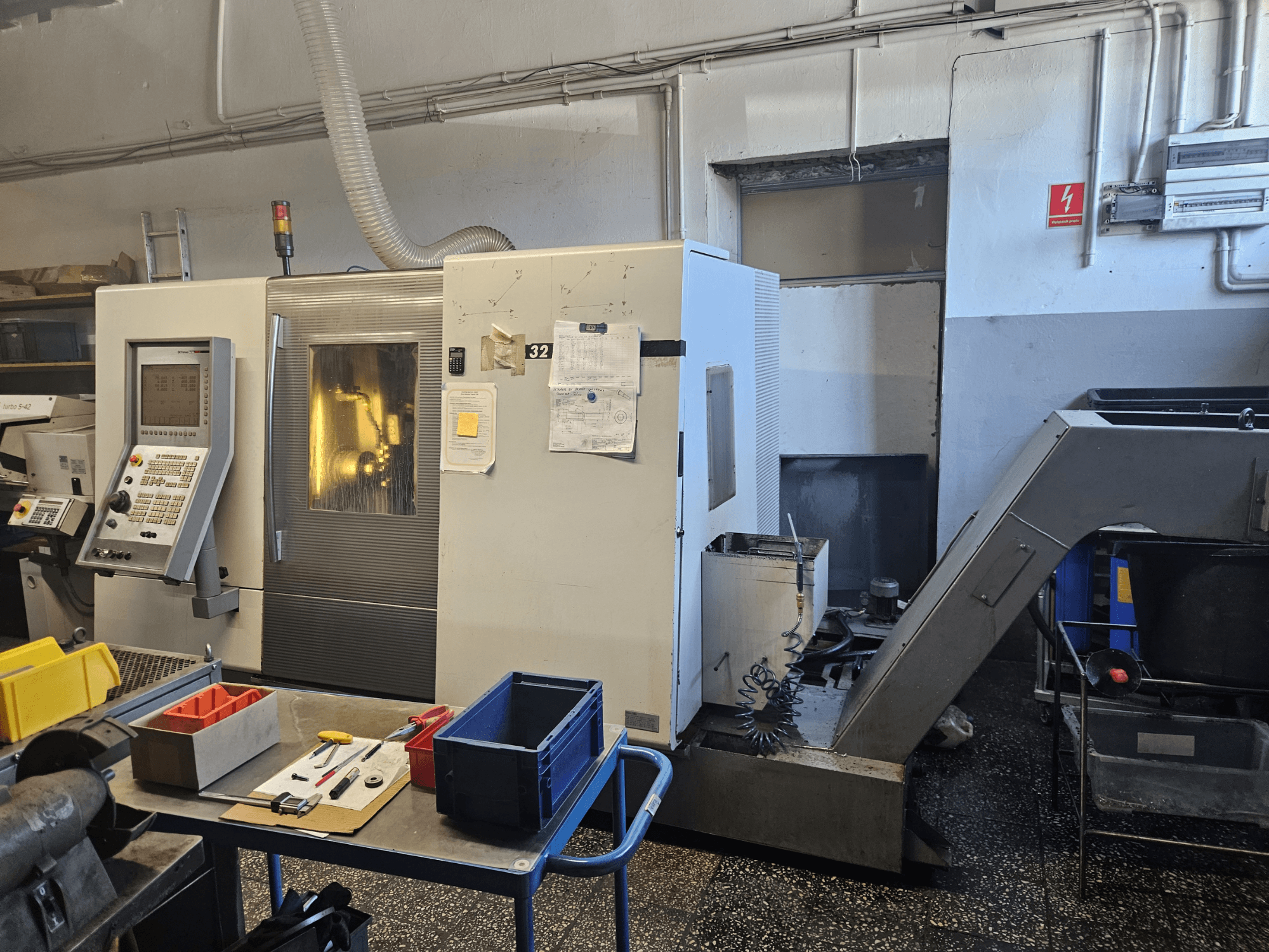 Tokarka wielowrzecionowa DMG GILDEMEISTER Sprint 32 linear, widok z przodu w warsztacie, widoczny panel sterowania i narzędzia.