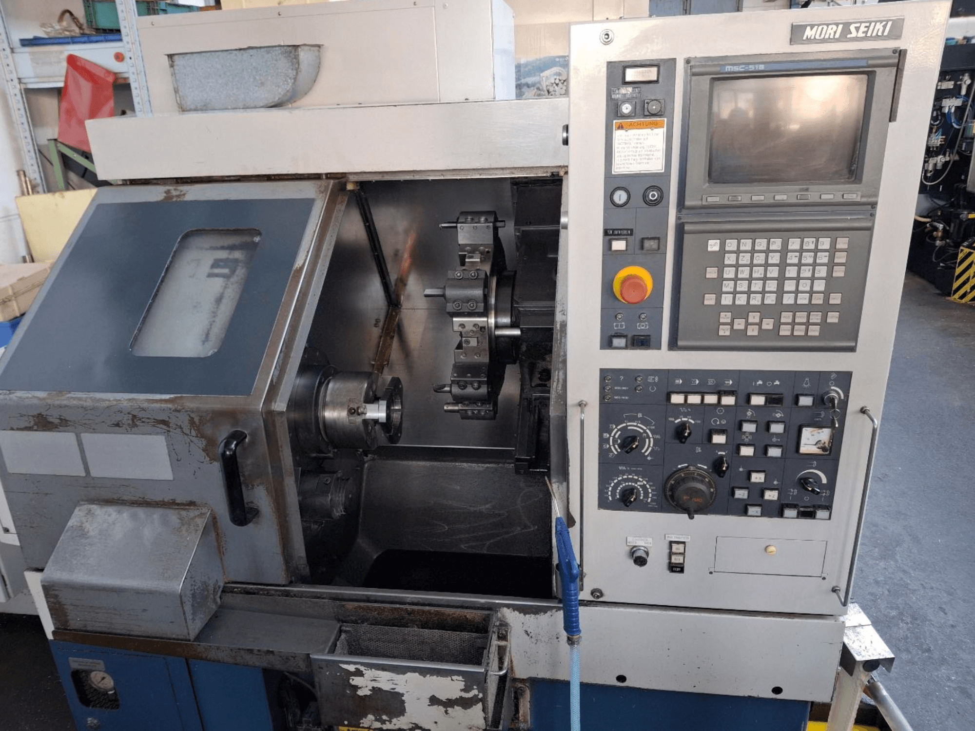Tokarka pozioma MORI SEIKI CL 15, widok z przodu przedstawiający panel sterowania i obszar obróbki.