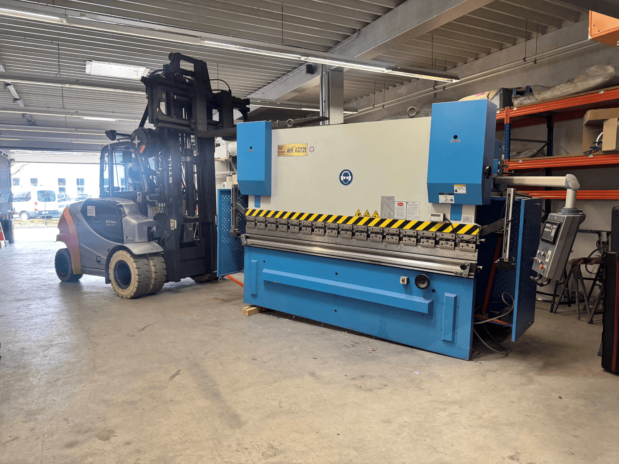 Prasa hydrauliczna KNUTH AHK A 32125 w warsztacie, widok z boku z panelem sterowania i funkcjami bezpieczeństwa.