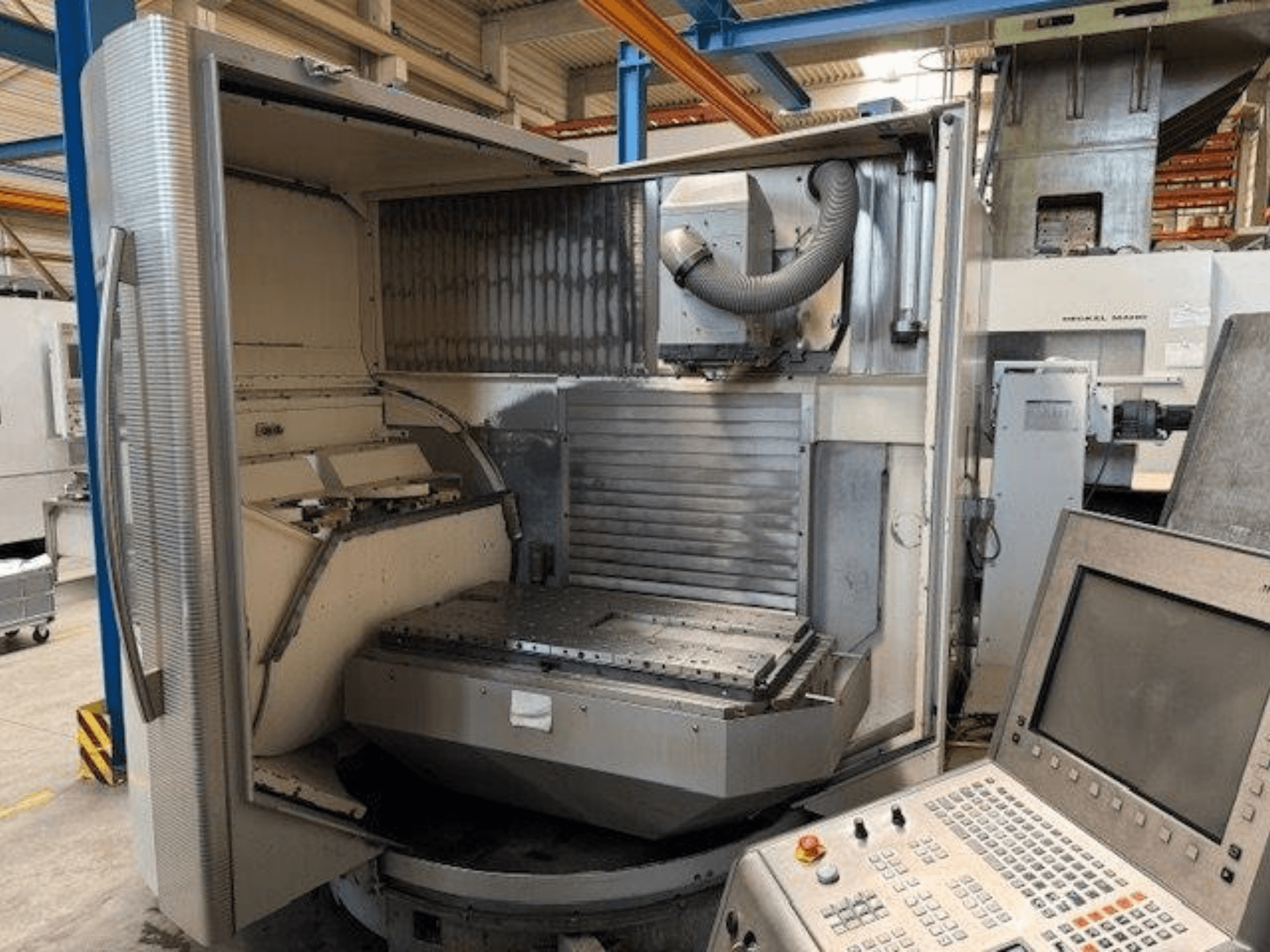 Pionowe centrum obróbcze DMG MORI DMU 80T, widok z przodu pokazujący otwartą obudowę i panel sterowania.