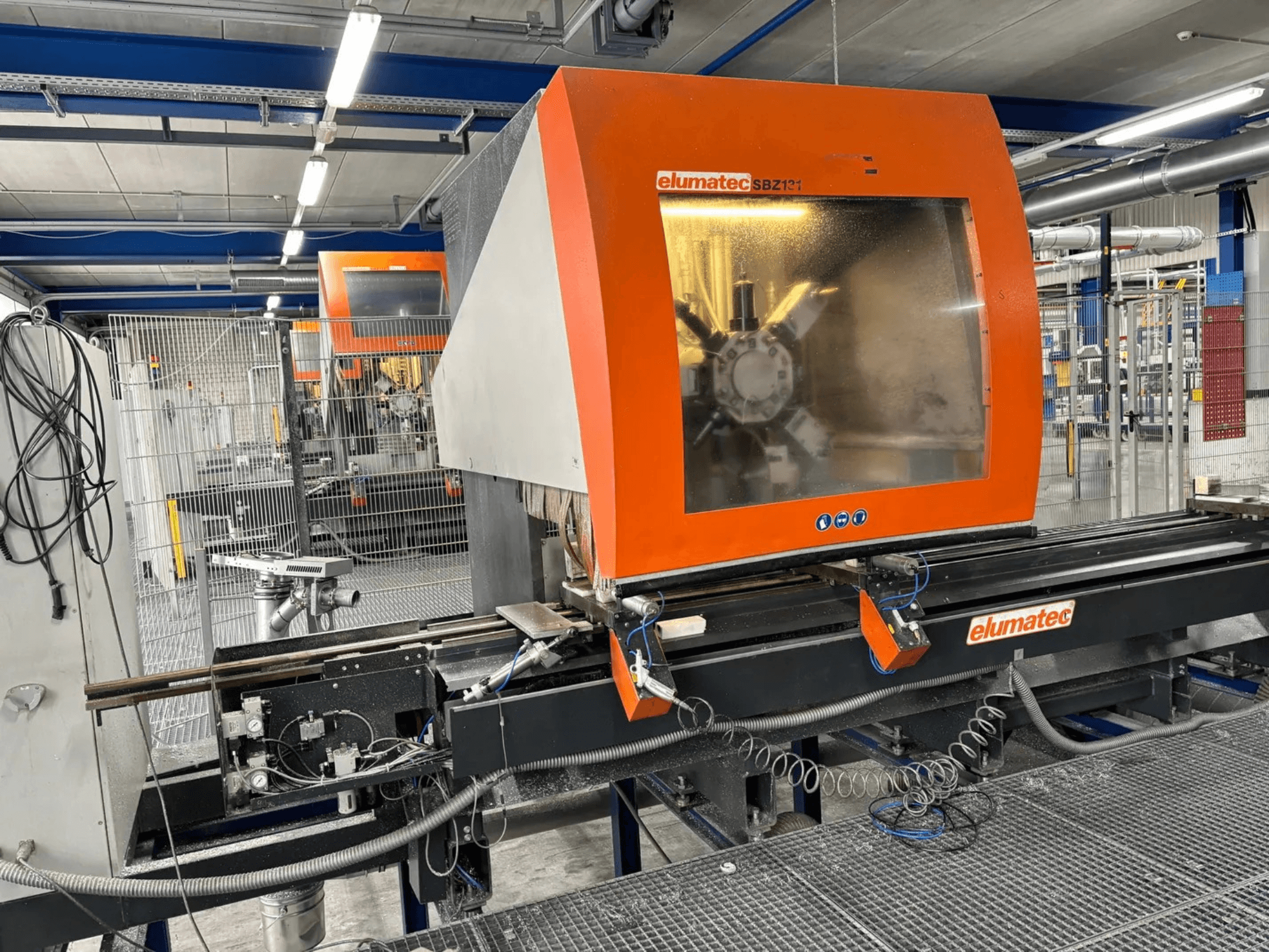Pionowe centrum obróbcze Elumatec SBZ 131, widok z przodu, panel sterowania, szczegóły maszyny i otaczające środowisko pracy.