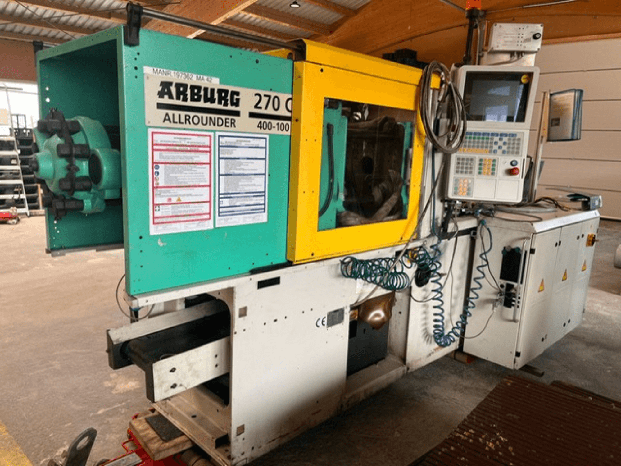 Widok z przodu hydraulicznej wtryskarki Arburg 270 C wraz z elementami sterującymi i szczegółami konstrukcyjnymi.