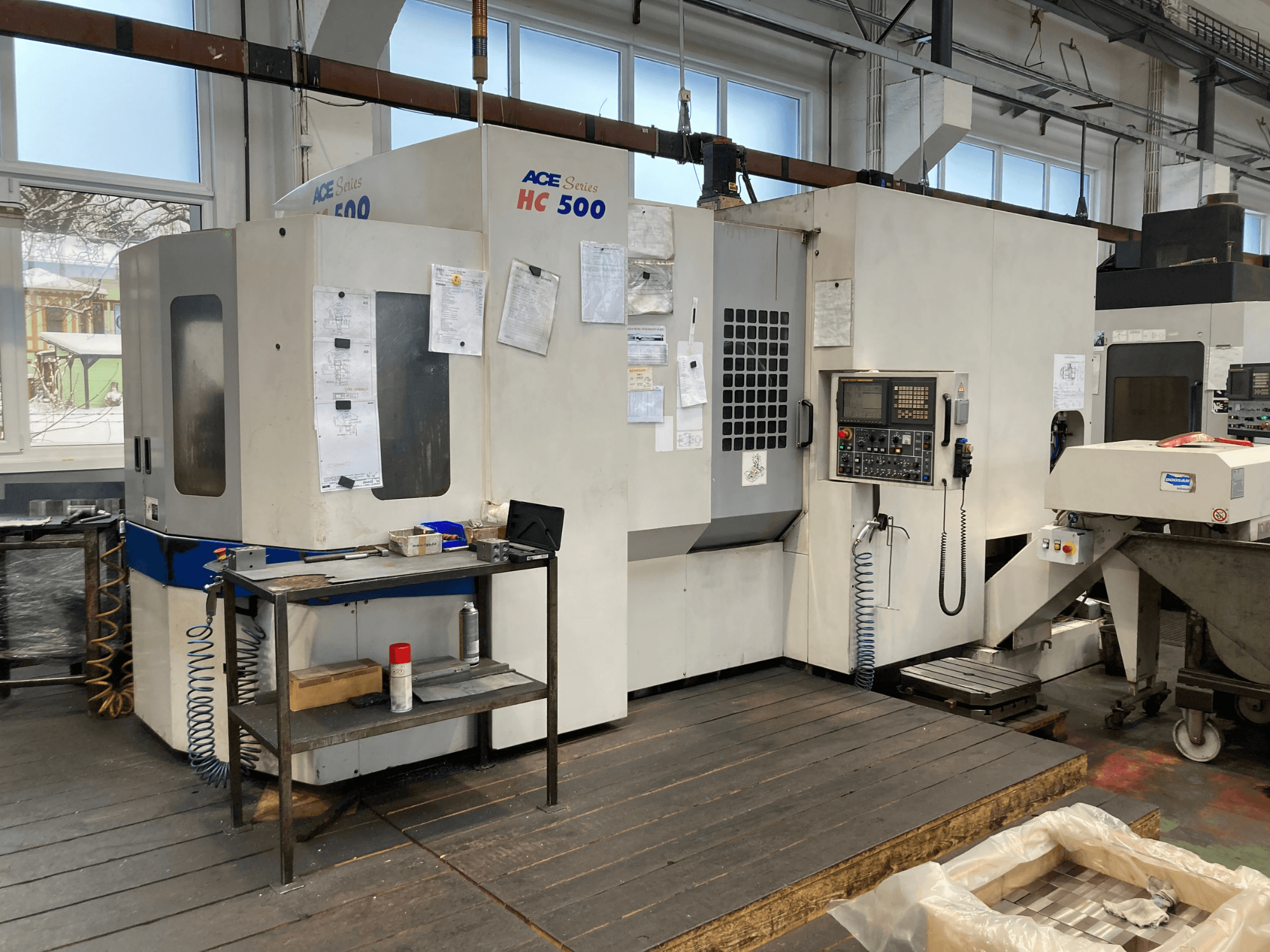 Poziome centrum obróbcze DOOSAN ACE HC-500, widok z przodu; posiada panel sterowania, wiele schowków na narzędzia i ustawienia przemysłowe.