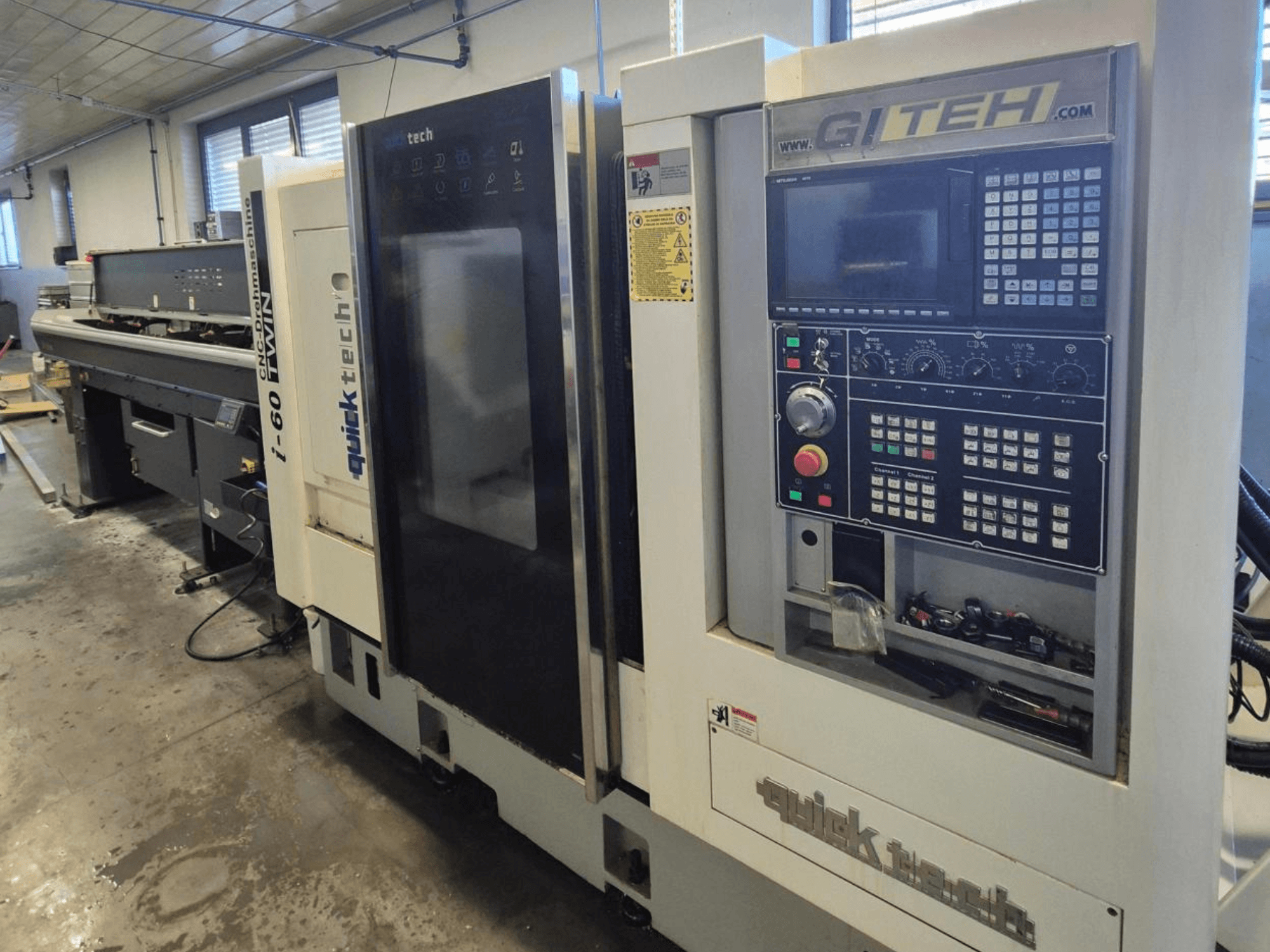 Podwójna maszyna CNC Quick Tech i-60, widok z przodu, z panelem sterowania GITEH i przyciskami operacyjnymi, w warunkach warsztatowych.