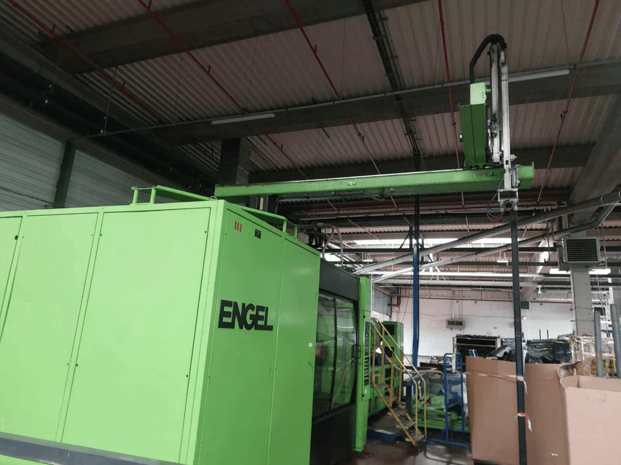 Zielona wtryskarka hydrauliczna Engel ES 16050/1100 DUO, widok z boku, obszar załadunku i panel sterowania.