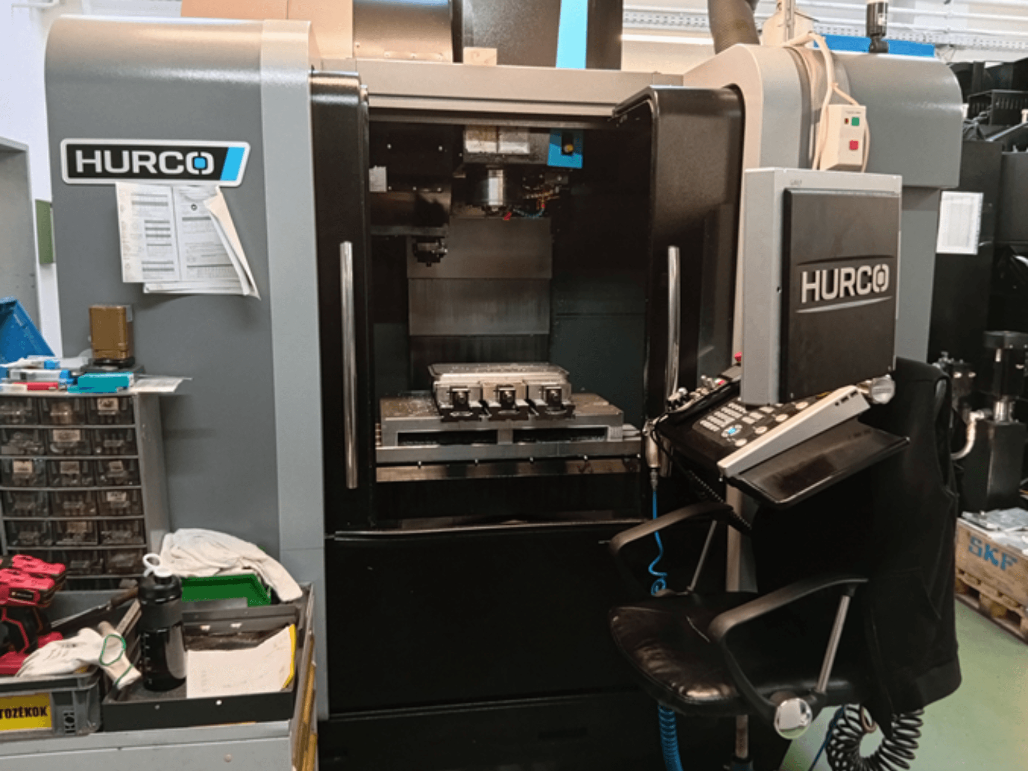 Pionowe centrum obróbcze Hurco VMX 30i w widoku z przodu, z panelem sterowania, stołem roboczym i konfiguracją operacyjną.