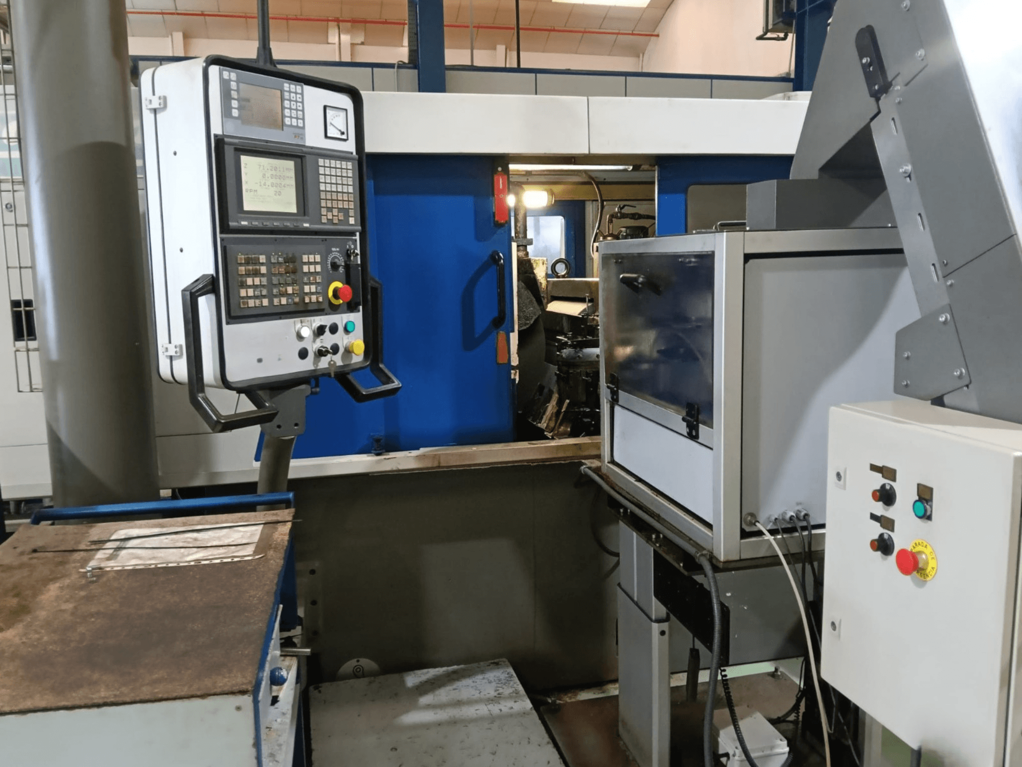 Panel sterowania i maszyny szlifierki bezkłowej DANOBAT 327 MDA, patrząc z boku, z przyciskami i wyświetlaczem.