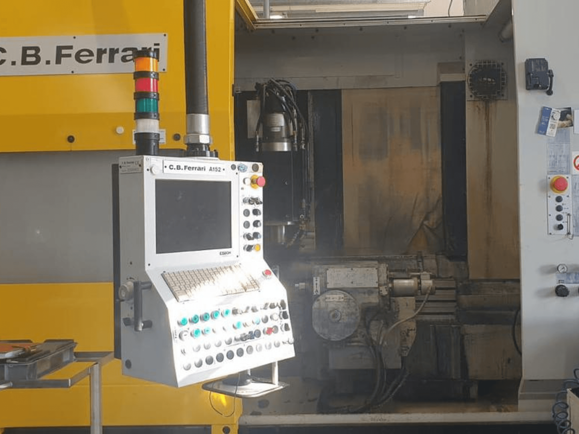 Widok z przodu pionowego centrum obróbczego C.B. Ferrari A152, przedstawiający panel sterowania z przyciskami i elementami silnika maszyny.