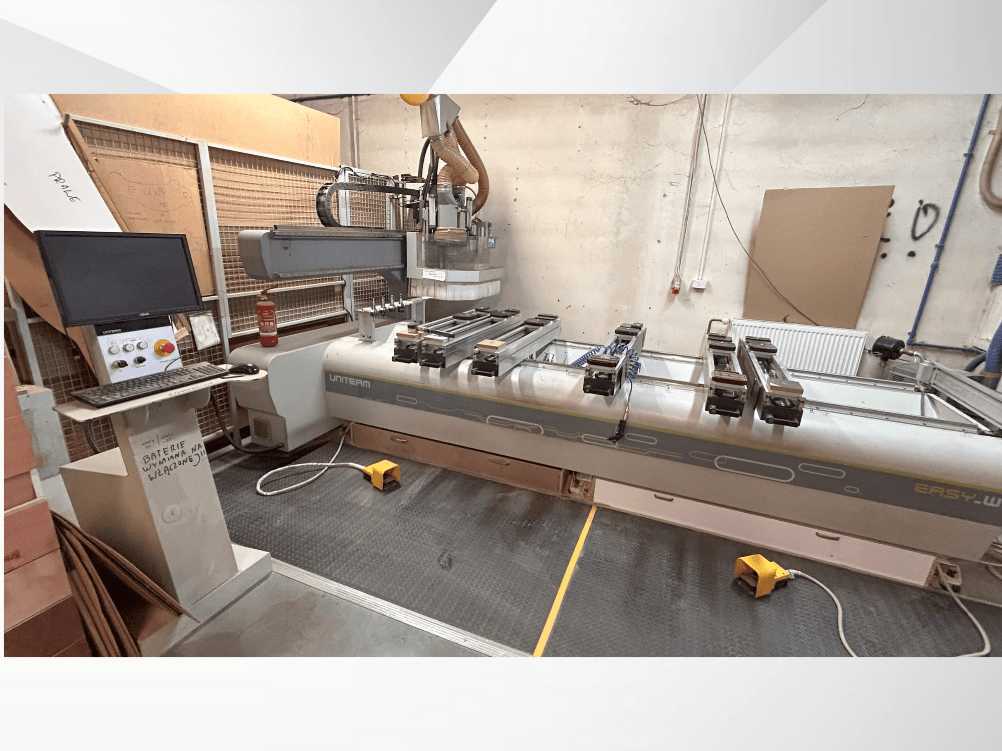 Widok z przodu maszyny CNC UNITEM EASY-W z panelem sterowania, monitorem i zamocowanymi elementami na stole roboczym.