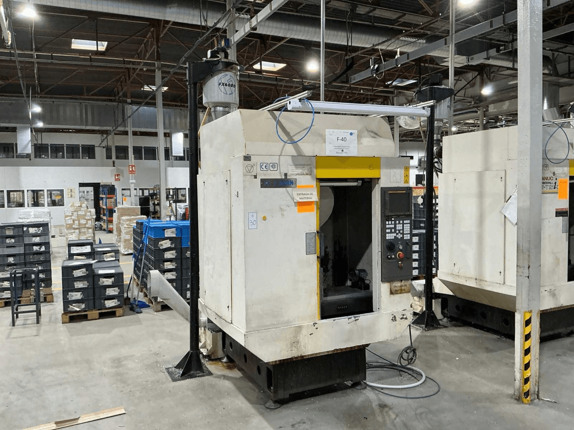 FANUC ROBODRILL α-T21iD, widok z przodu pionowego centrum obróbczego w środowisku przemysłowym, z widocznymi szczegółami panelu sterowania.