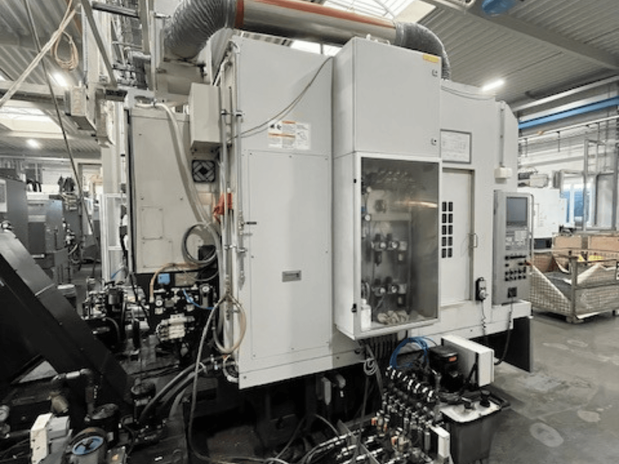 Widok z boku maszyny przemysłowej z panelem sterowania i komponentami hydraulicznymi, prezentujący szczegóły marki i modelu.