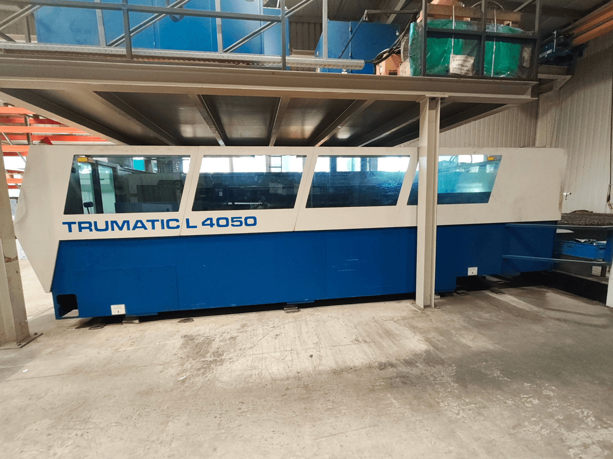 Maszyna do cięcia laserowego CO₂ TRUMPF TruLaser 450 widziana z boku, w niebiesko-białej kolorystyce, z widocznym panelem sterowania i obszarem roboczym.